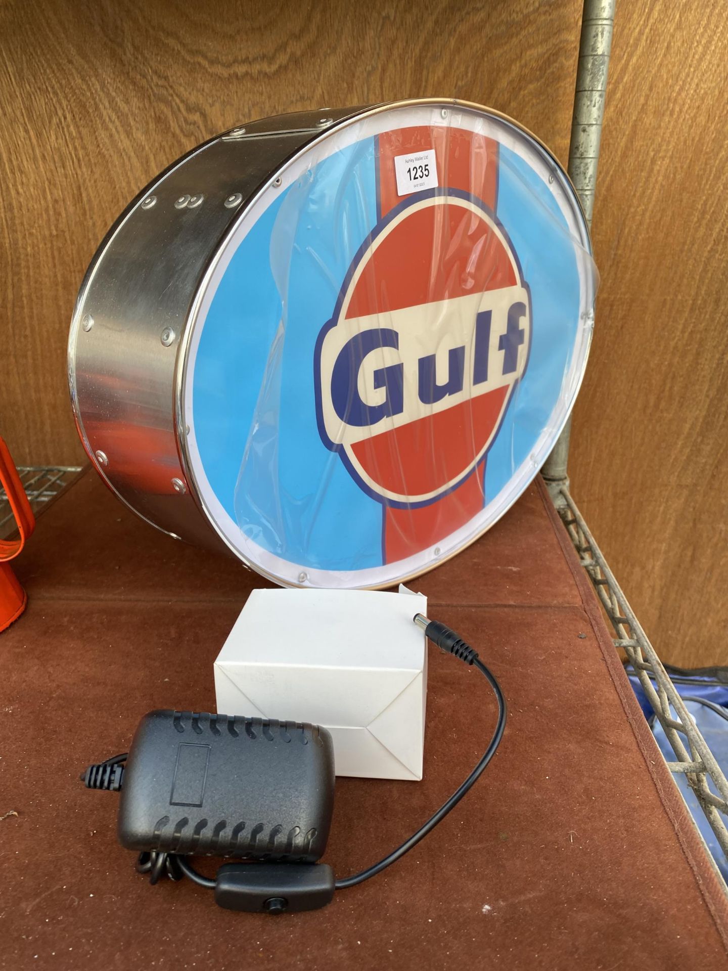AN ILLUMINATED 'GULF SIGN WITH PLUG AND CABLE
