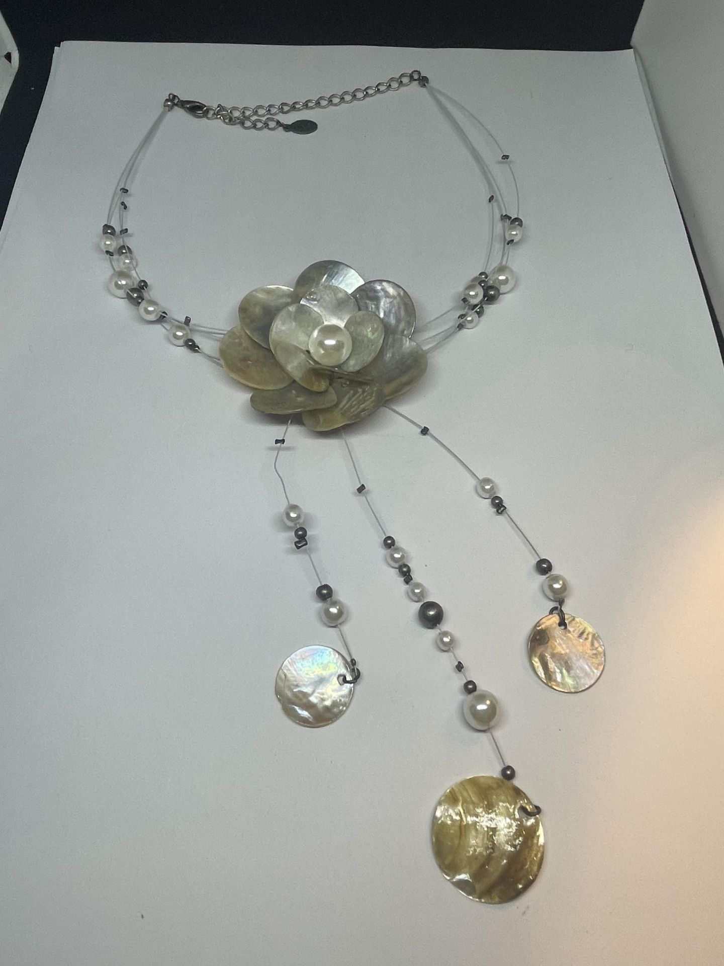 A DECORATIVE SHELL NECKLACE IN A FLOWER DESIGN