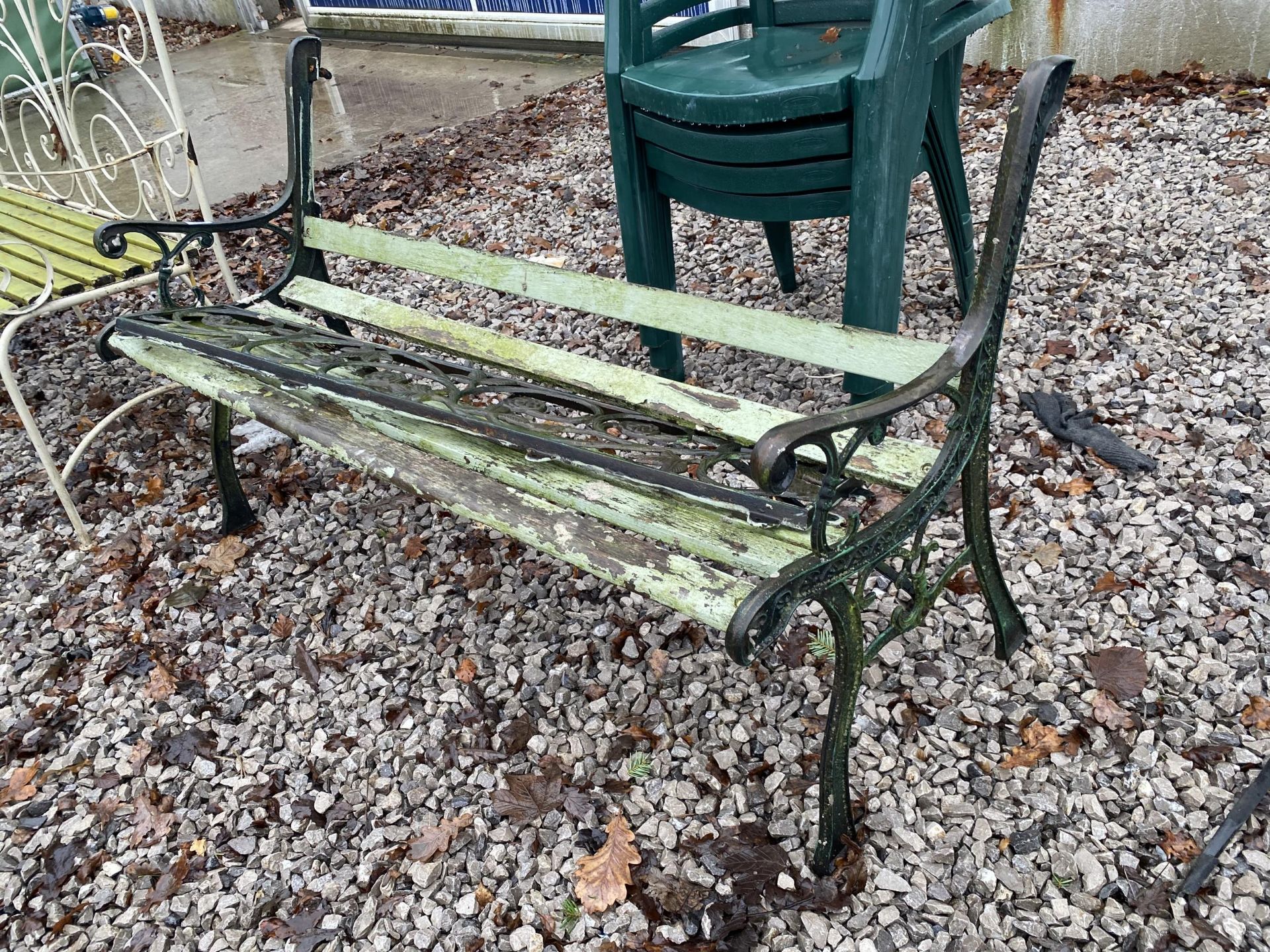 A WOODEN SLATTED GARDEN BENCH WITH CAST ENDS AND BACK FOR RESTORATION