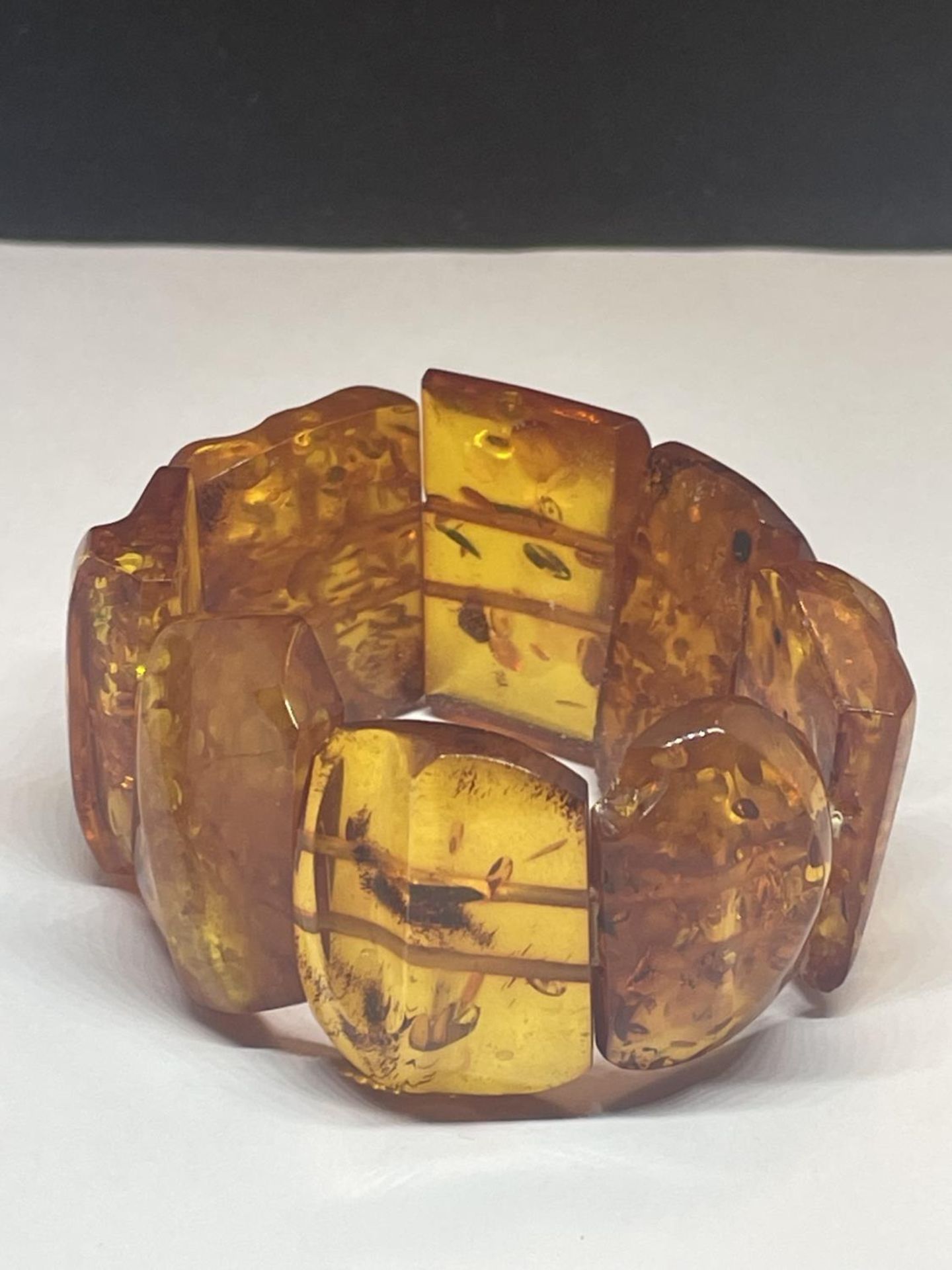 AN AMBER BRACELET CONSISTING OF EIGHT RECTANGULAR STYLE STONES