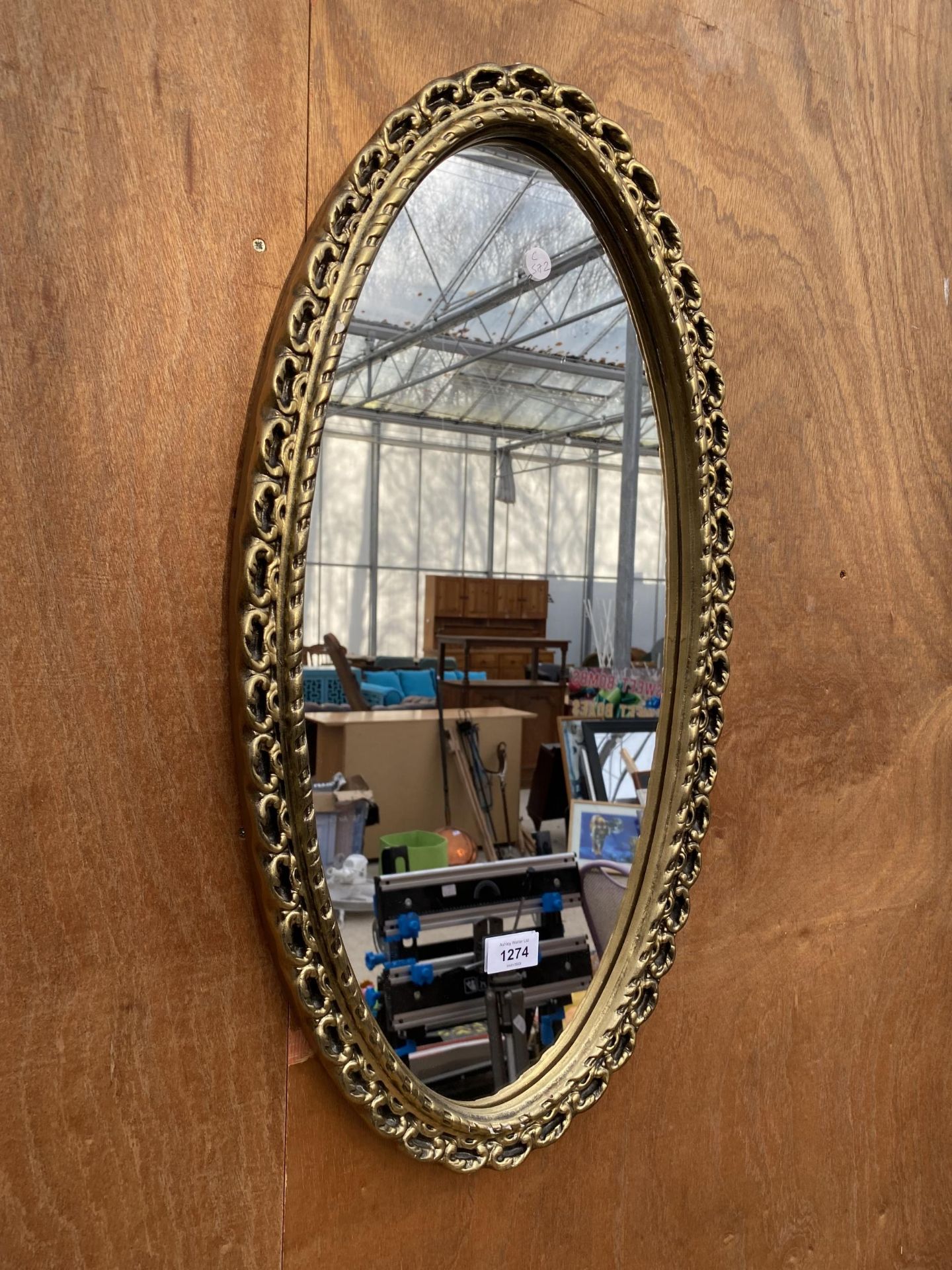 A DECORATIVE GILT FRAMED OVAL WALL MIRROR