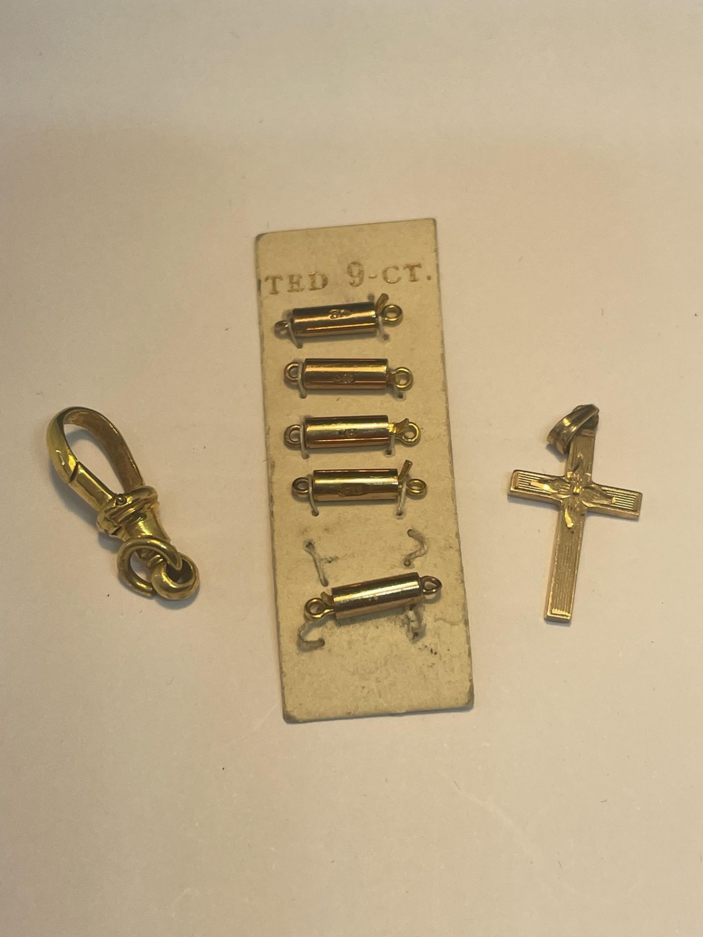 SEVEN 9 CARAT GOLD ITEMS TO INCLUDE A CROSS PENDANT, A CLIP AND FIVE FASTENERS