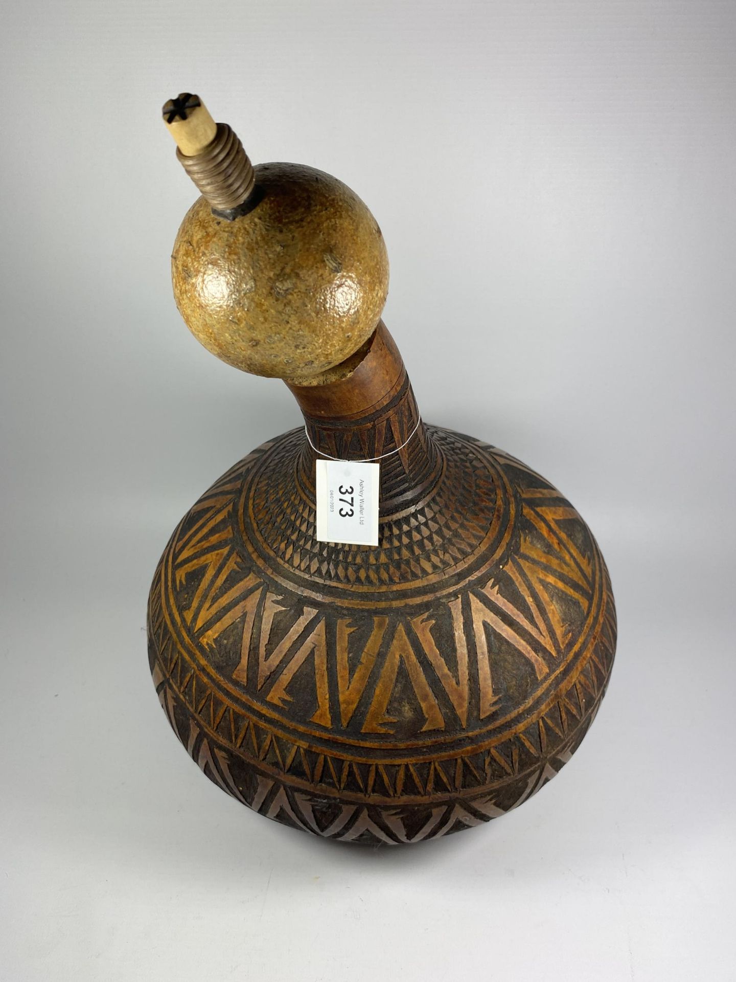 A VINTAGE TRIBAL CARVED WOODEN POPPY SEED GOURD AND SHAKER, HEIGHT