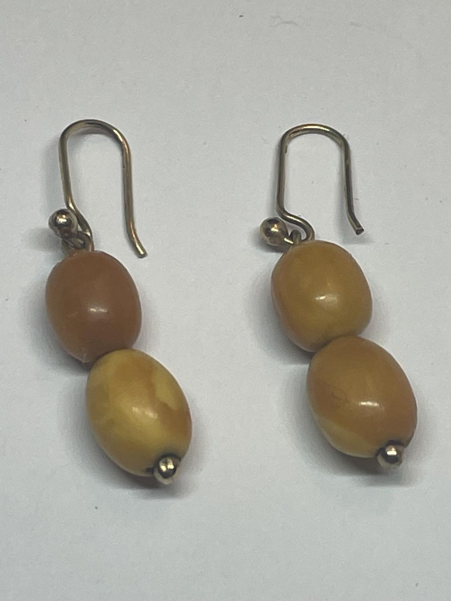 A APIR OF BUTTERSCOTCH AMBER TWO STONE DROP EARRINGS IN A PRESENTATION BOX