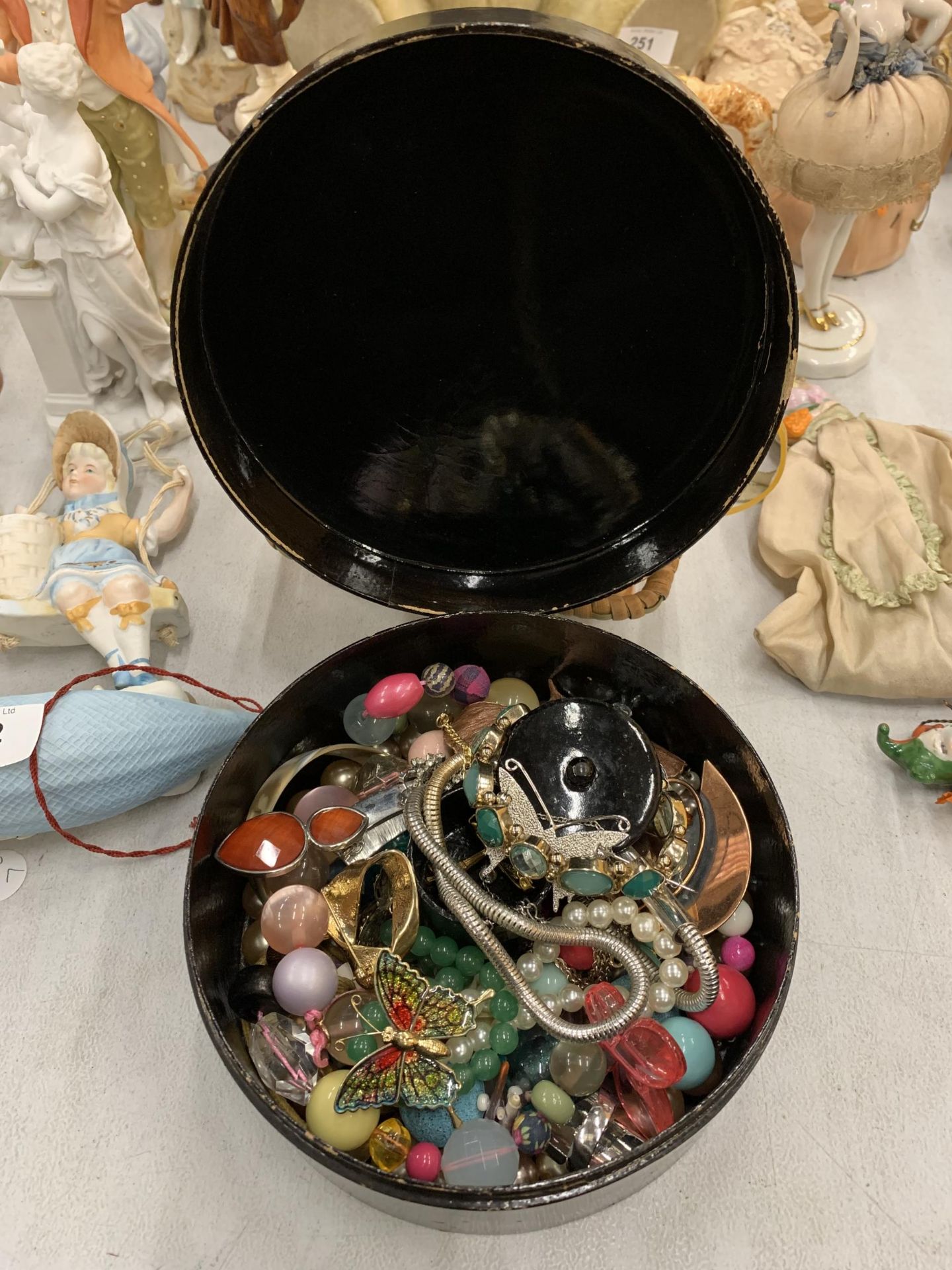 AN ORIENTAL STYLE LACQUERED BOX CONTAINING A QUANTITY OF COSTUME JEWELLERY TO INCLUDE NECKLACES,