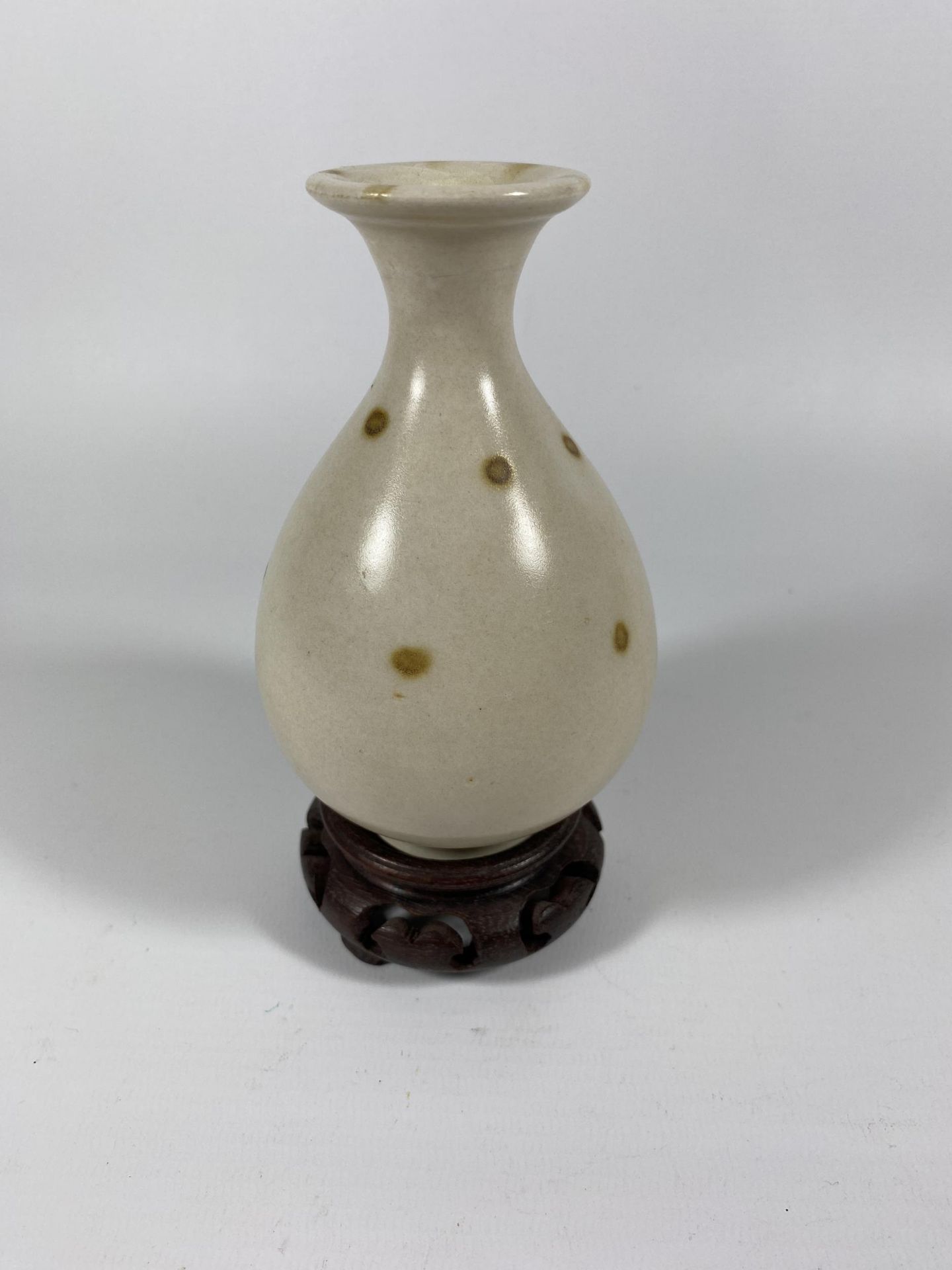 A CHINESE PORCELAIN BOTTLE VASE ON CARVED WOODEN STAND, HEIGHT OF VASE 13CM
