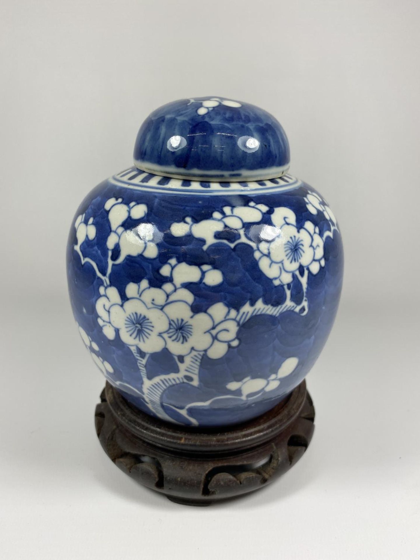 A LATE 19TH CENTURY CHINESE PORCELAIN PRUNUS BLOSSOM PATTERN GINGER JAR ON WOODEN BASE, DOUBLE