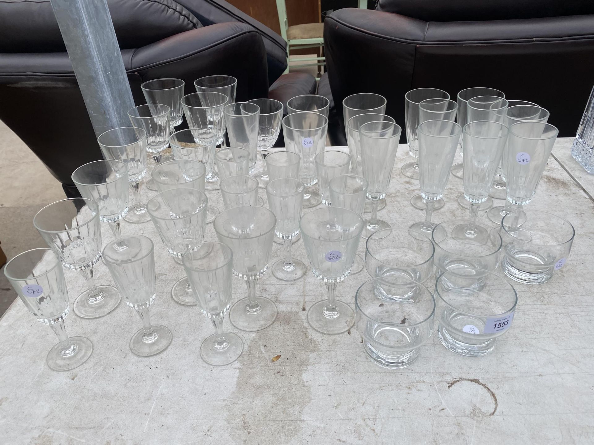 A LARGE ASSORTMENT OF GLASS WARE TO INCLUDE WINE GLASSES AND CHAMPAGNE FLUTES ETC