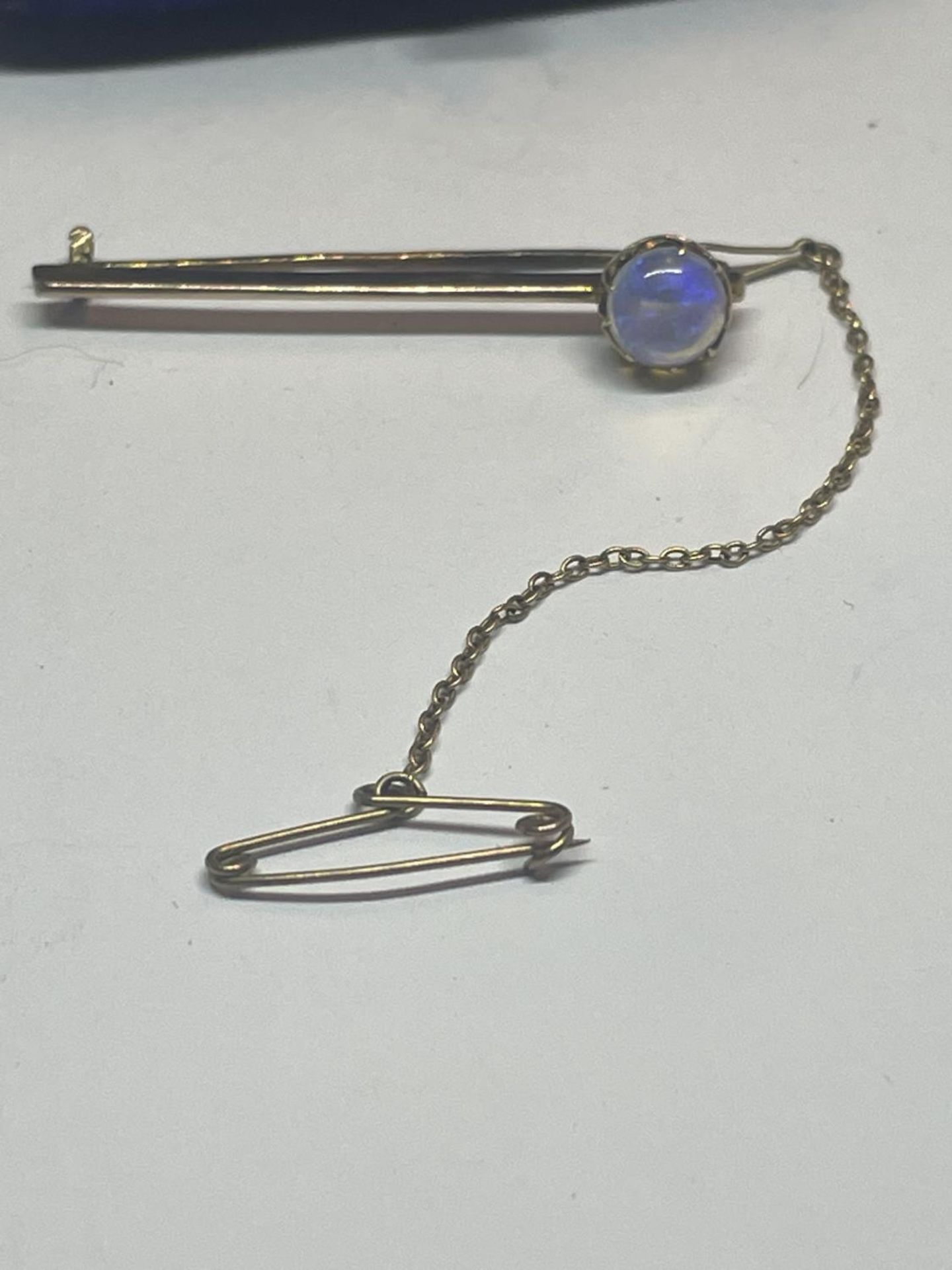 A 9 CARAT GOLD BROOCH WITH OPAL AND A SAFETY CHAIN GROSS WEIGHT 1.92 GRAMS IN A PRESENTATION BOX