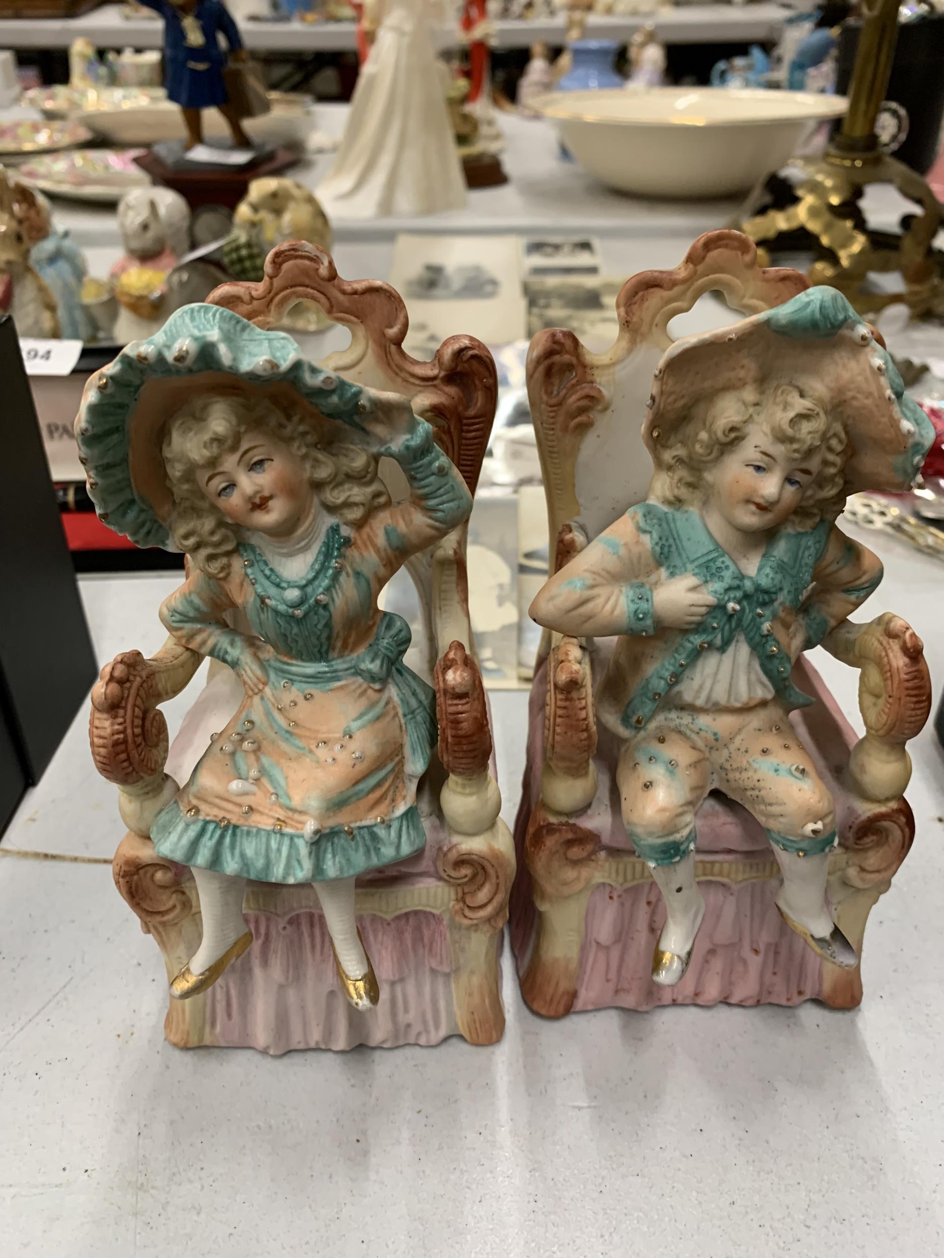 A PAIR OF BISQUE CONTINENTAL SEATED FIGURES