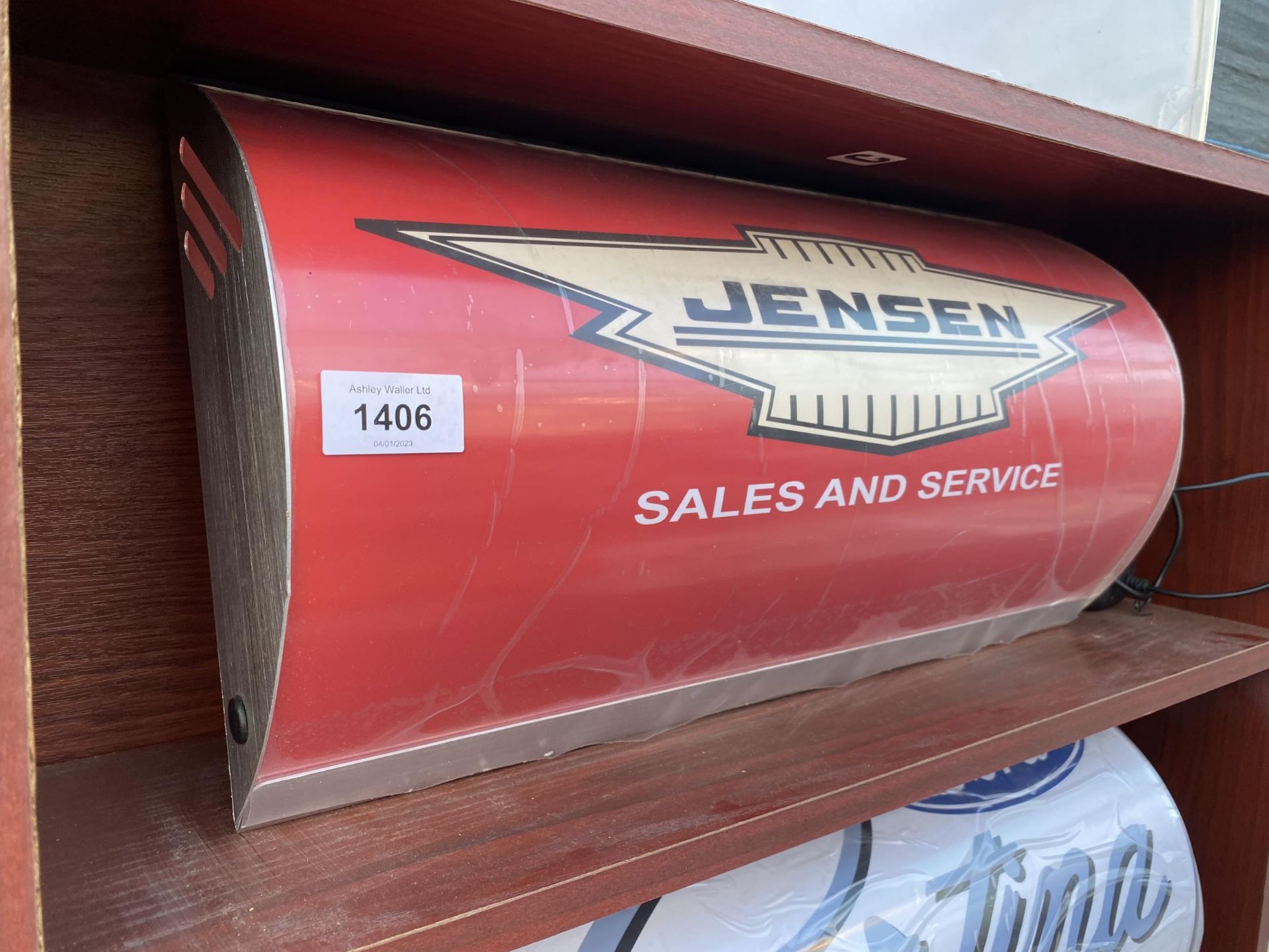 AN ILLUMINATED 'JENSEN' SIGN WITH PLUG AND LEAD