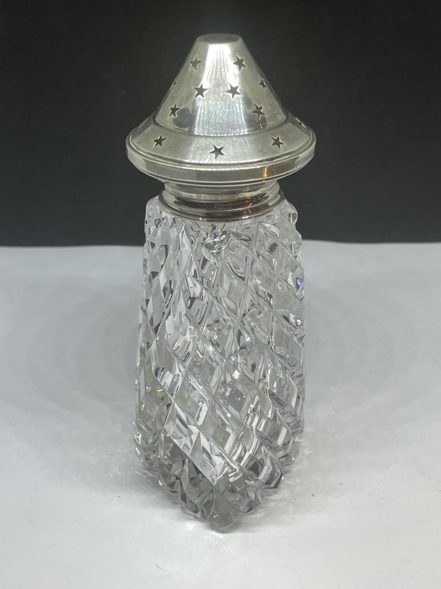 A CUT GLASS AND HALLMARKED BIRMINGHAM SILVER TOPPED SIFTER