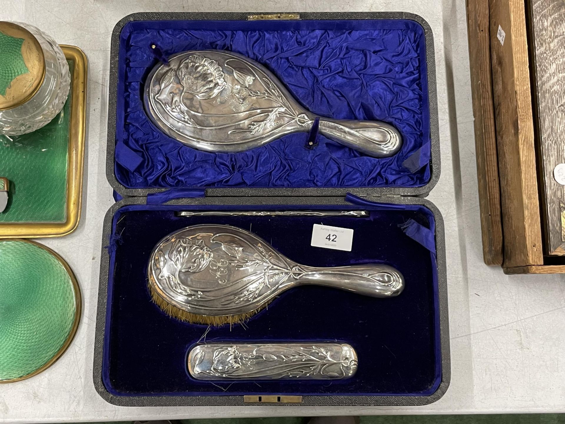 AN ART NOUVEAU SILVER BACKED FOUR PIECE DRESSING TABLE SET IN ORIGINAL CASE, WITH SILVER