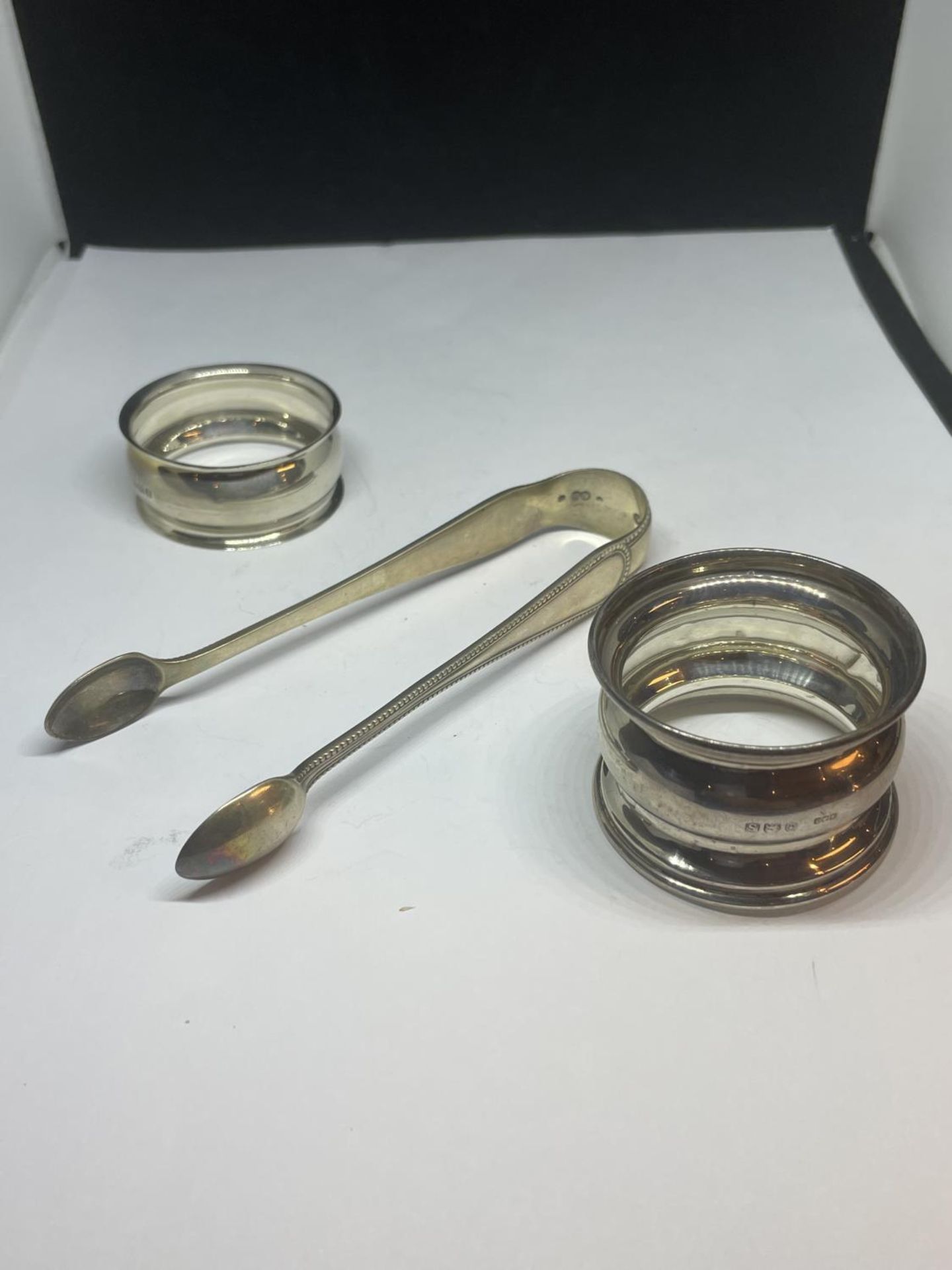 THREE SILVER ITEMS TO INCLUDE TWO HALLMARKED BIRMINGHAM SILVER NAPKIN RINGS ONE 1942 AND ONE