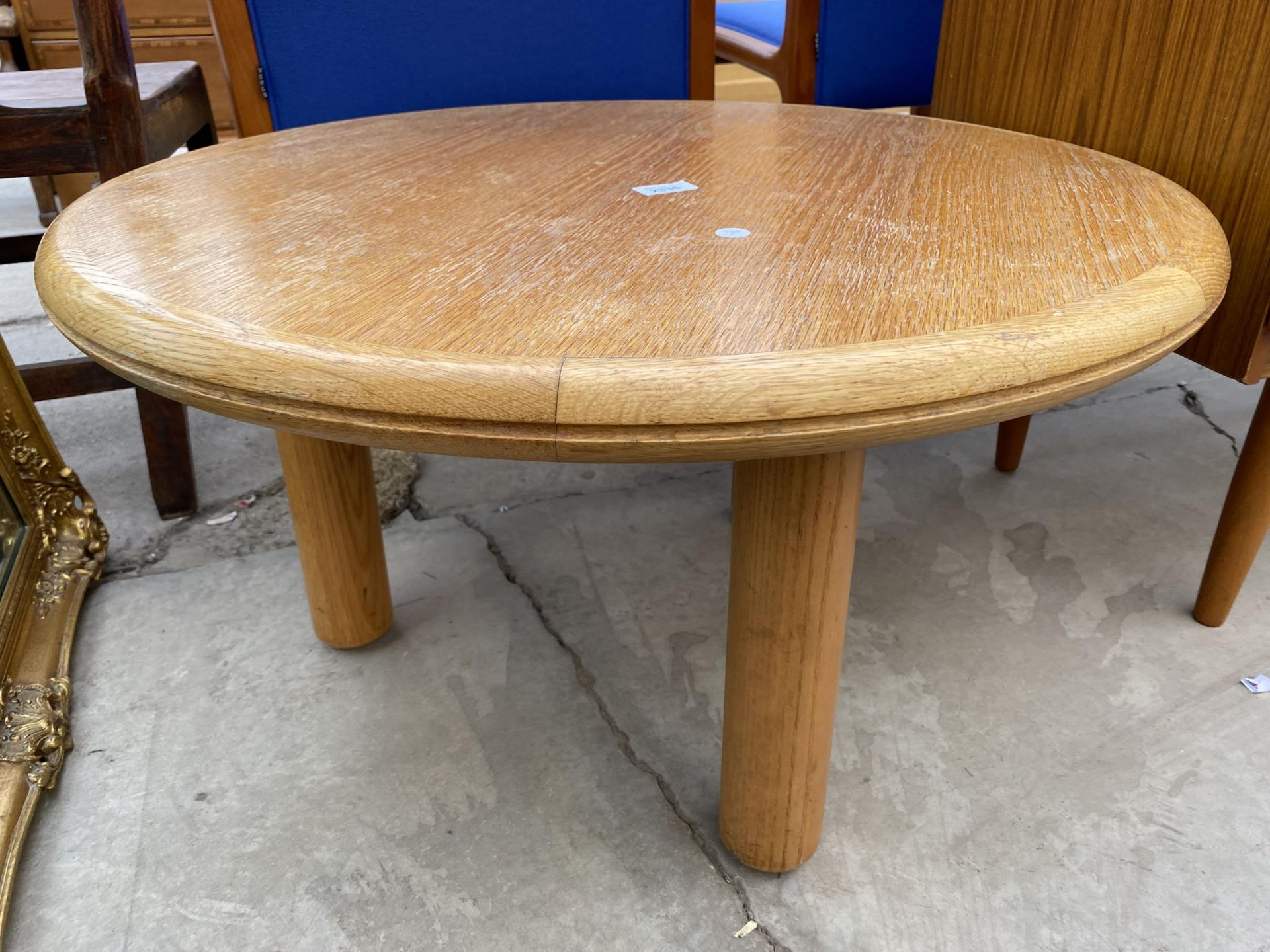 A 29" DIAMETER 'GORDON RUSSELL' OAK COFFEE TABLE ON THREE PILLAR LEGS