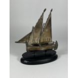 A SILVER STAMPED MODEL OF A SHIP ON WOODEN BASE