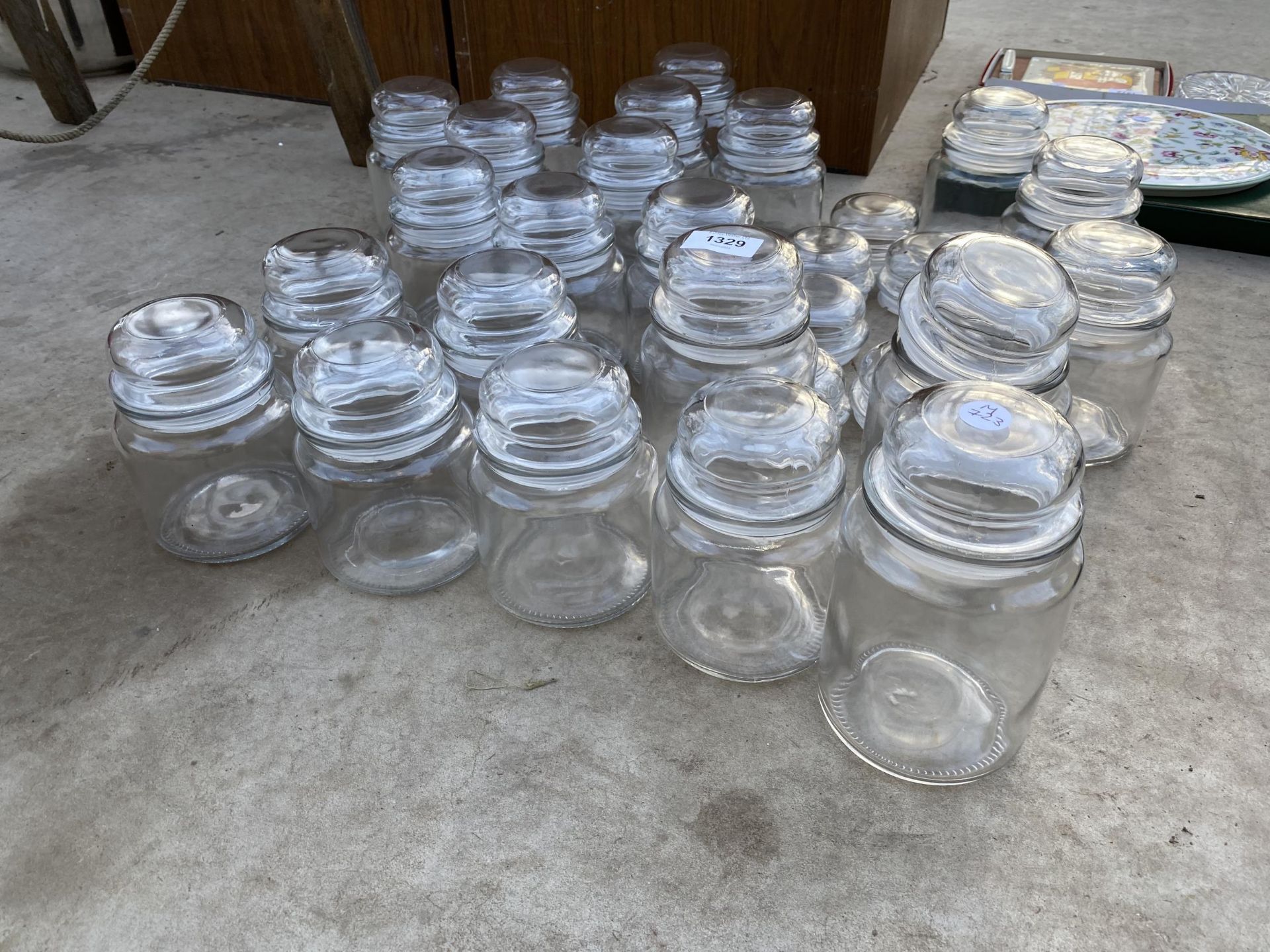 A LARGE ASSORTMENT OF GLASS STORAGE JARS WITH LIDS