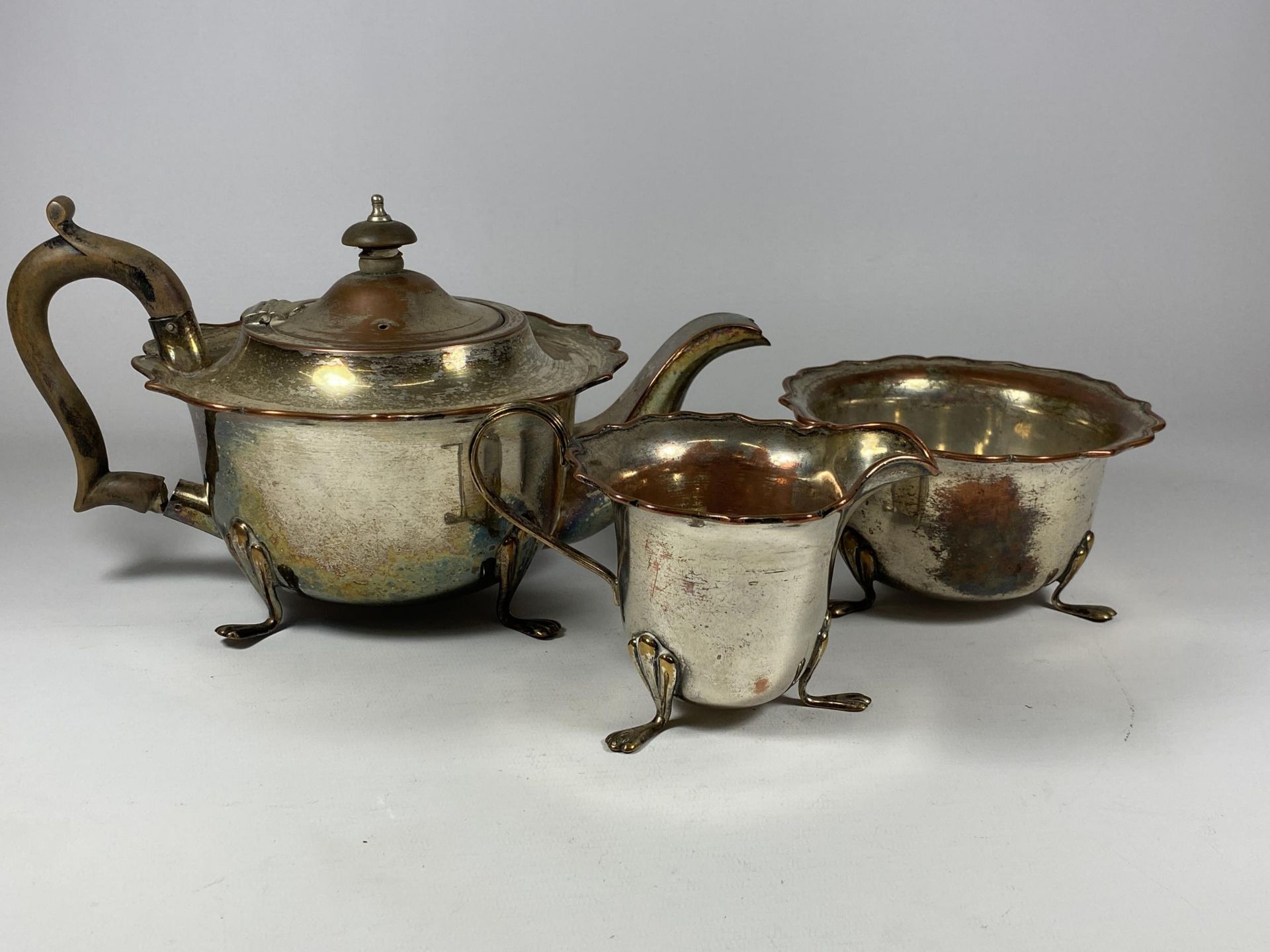 A VINTAGE SILVER PLATE ON COPPER THREE PIECE TEA SET