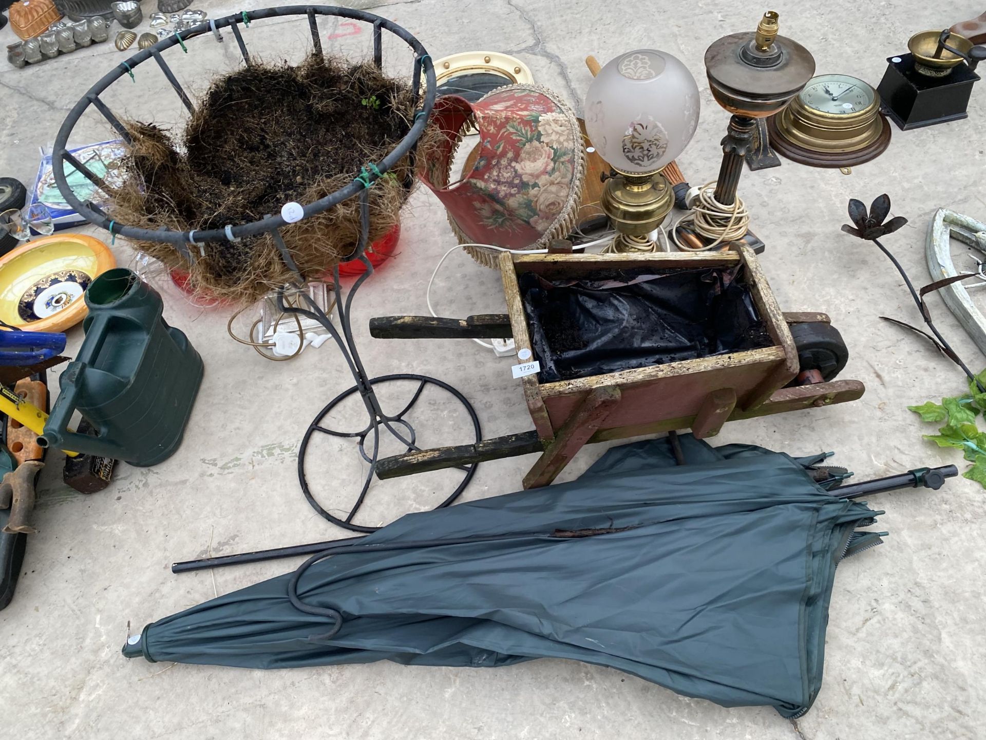 A WOODEN WHEEL BARROW PLANTER, A WROUGHT IRON PLANTER AND A FISHING BROLLY