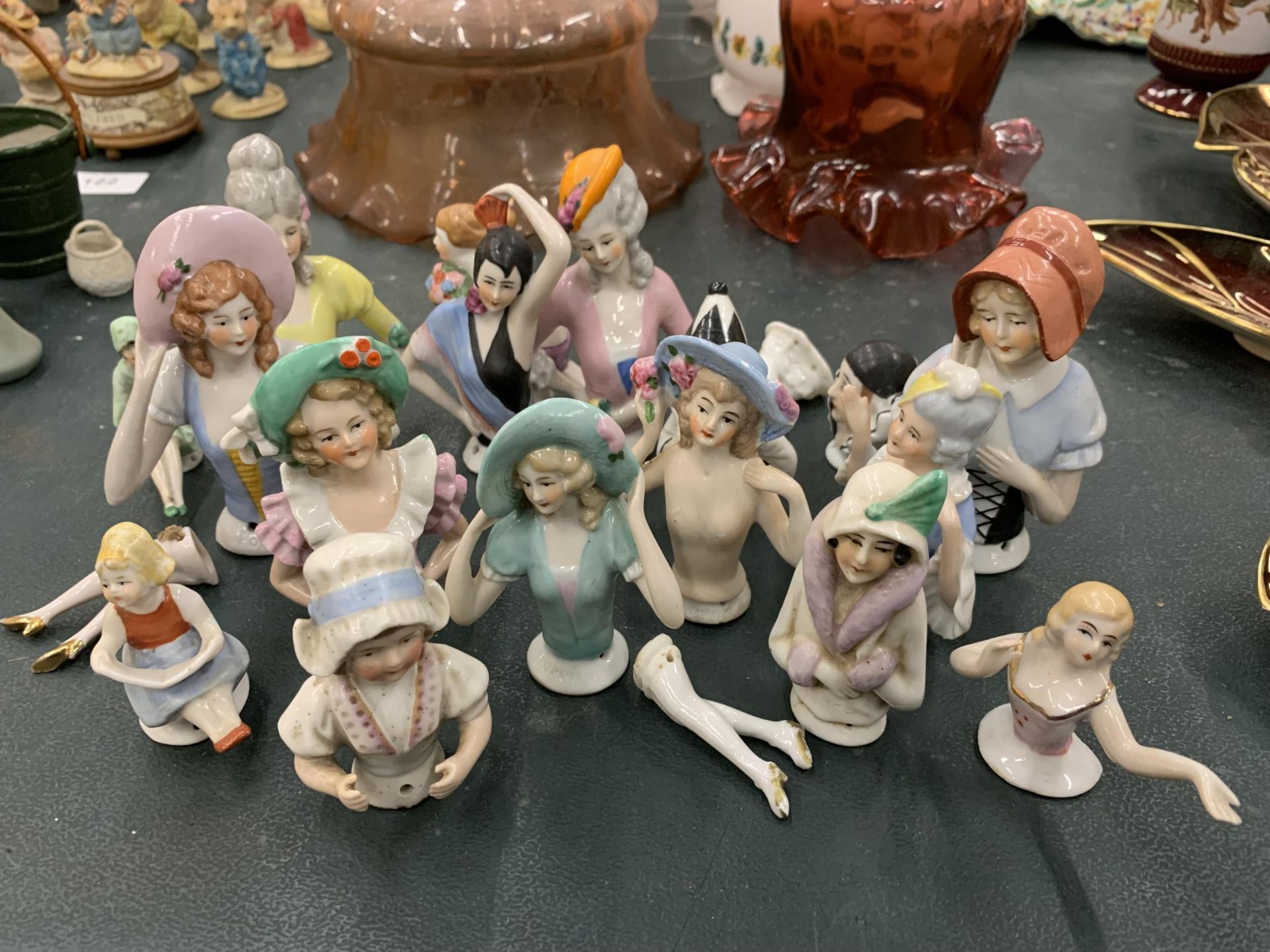 A COLLECTION OF CERAMIC SEWING/PIN CUSHION LADIES