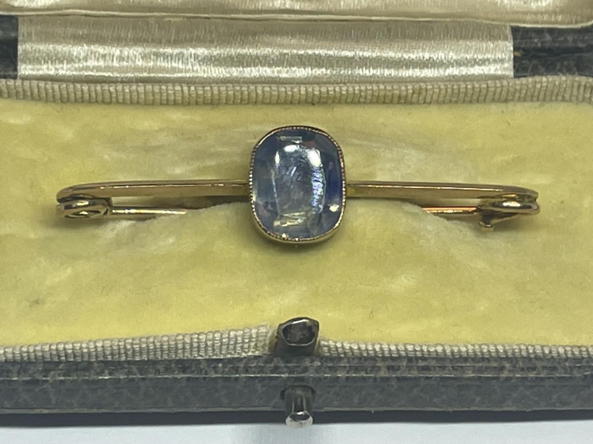 A 9 CARAT GOLD BROOCH WITH PLAE BLUE STONE GROSS WEIGHT 3.24 GRAMS IN A PRESENTATION BOX