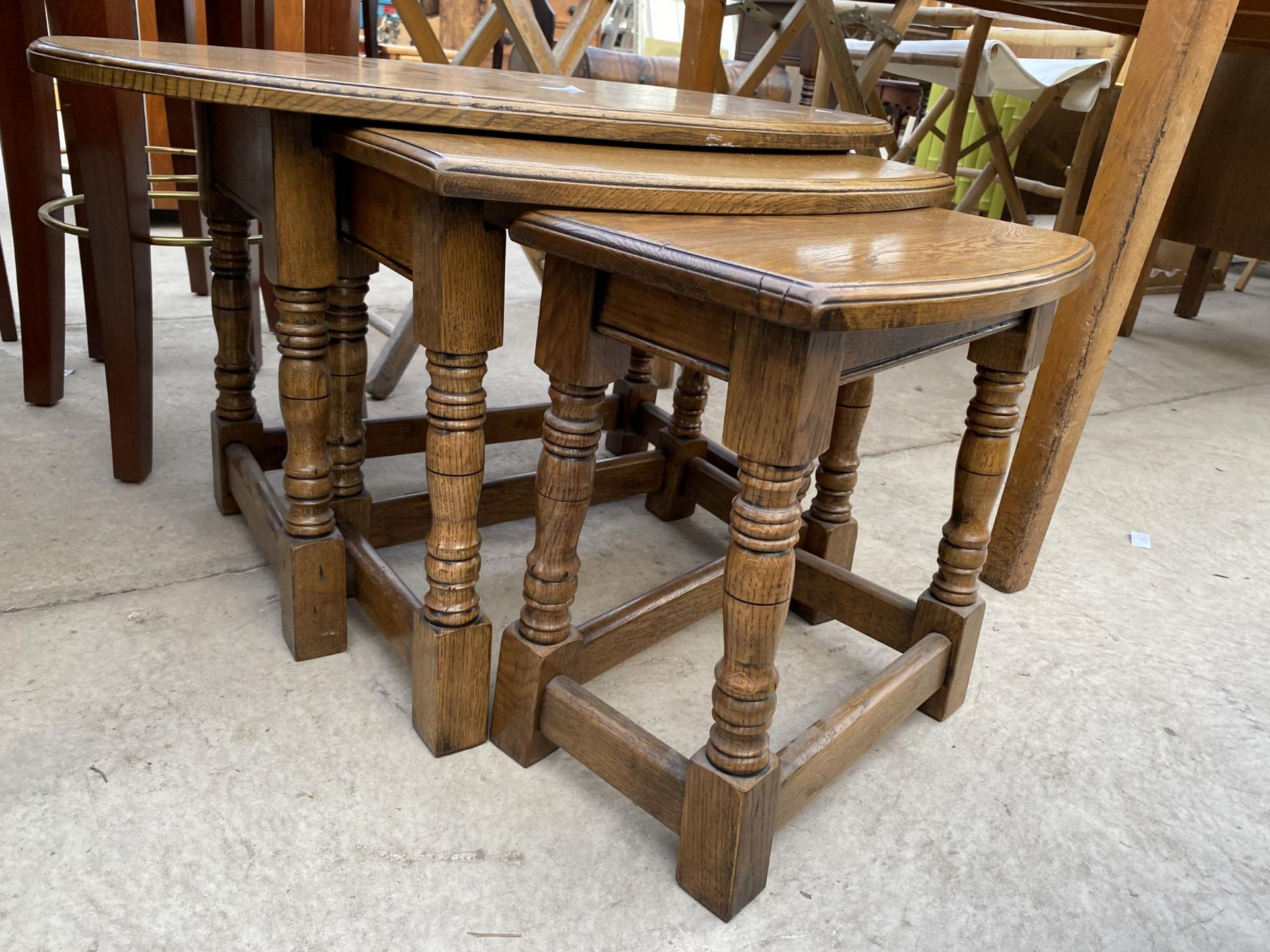 AN OVAL OAK NEST OF THREE TABLES ON TURNED LEGS - Image 2 of 2