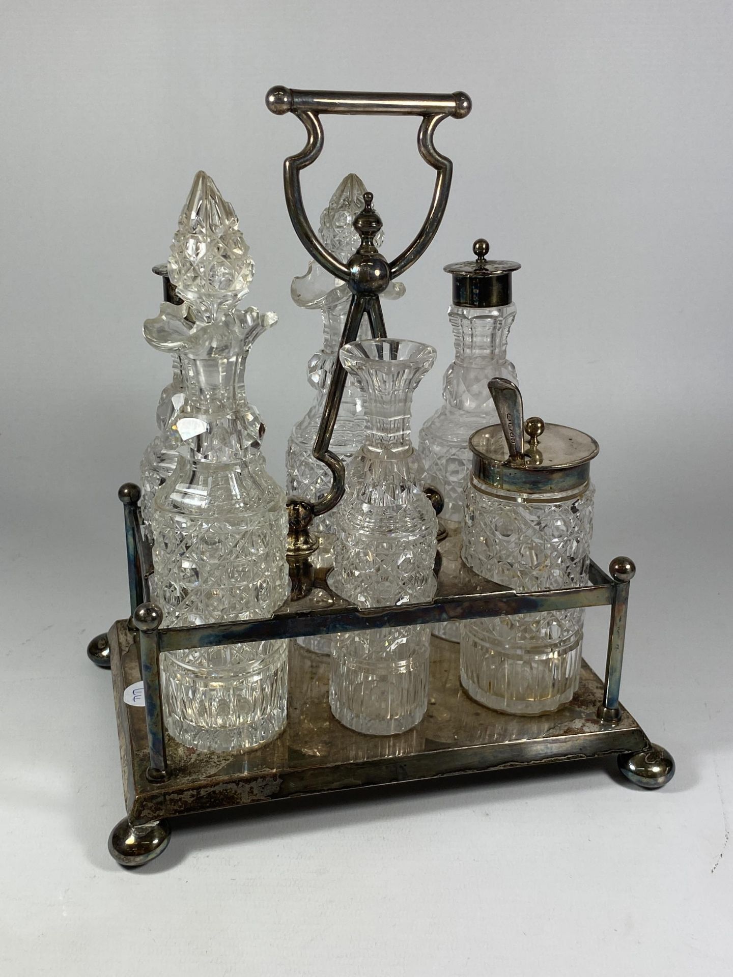 A SILVER PLATED CONDIMENT SET WITH CUT GLASS BOTTLES