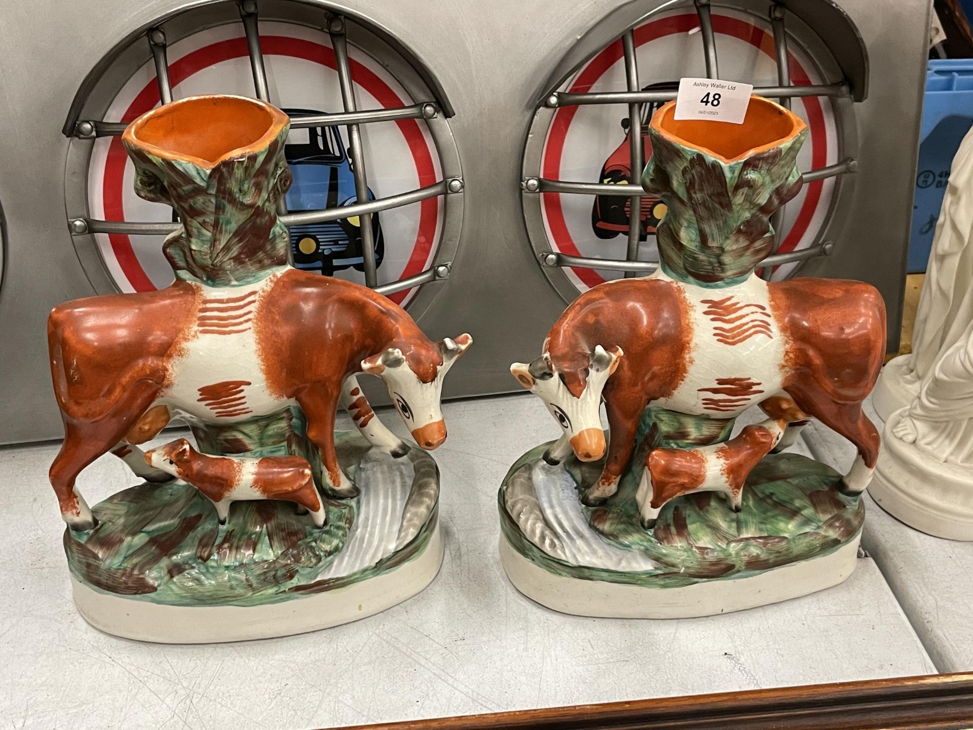 A PAIR OF 19TH CENTURY STAFFORDSHIRE POTTERY COW SPILL VASES