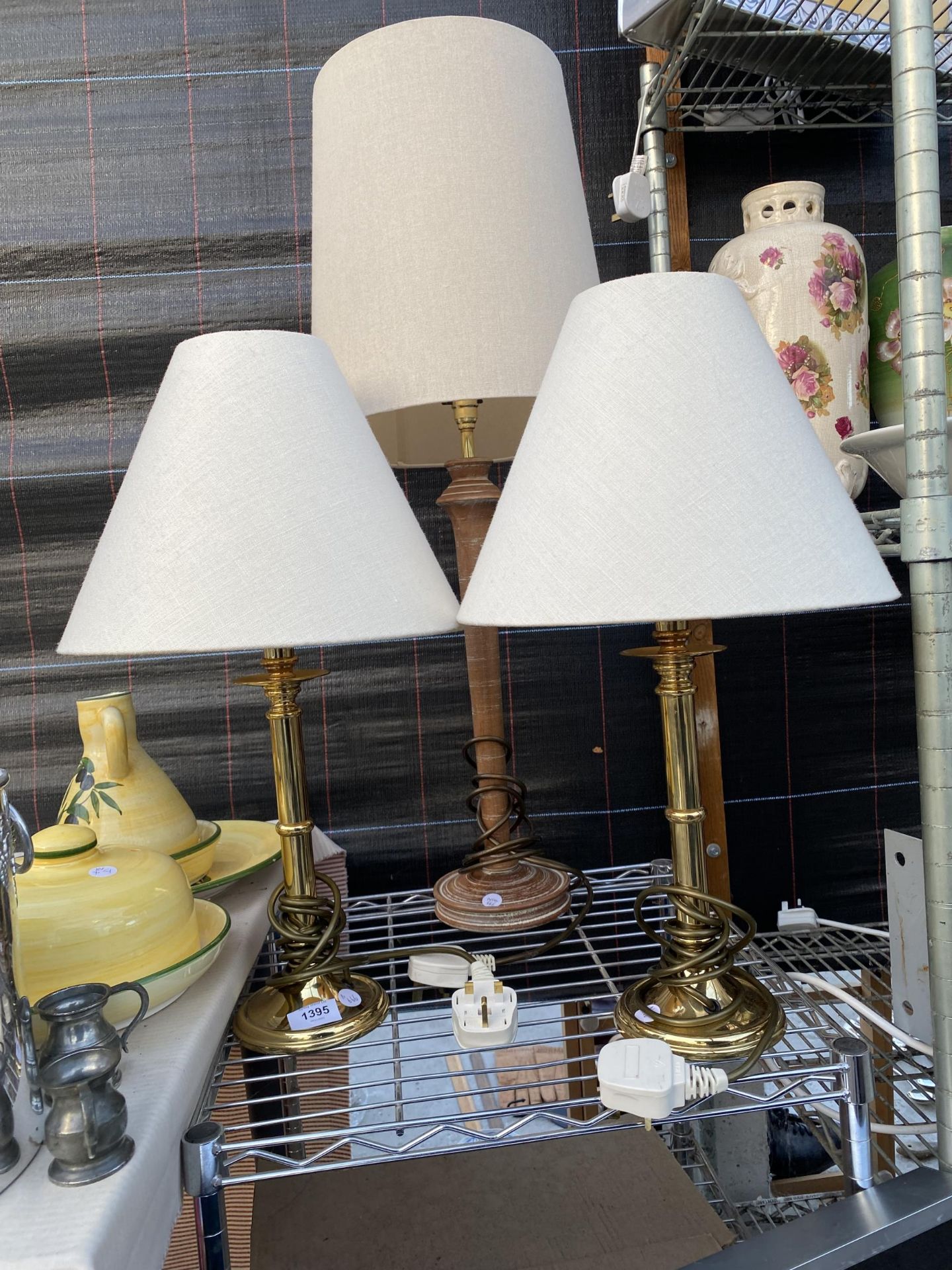 A PAIR OF BRASS TABLE LAMPS AND A FURTHER WOODEN TABLE LAMP ALL COMPLETE WITH SHADES