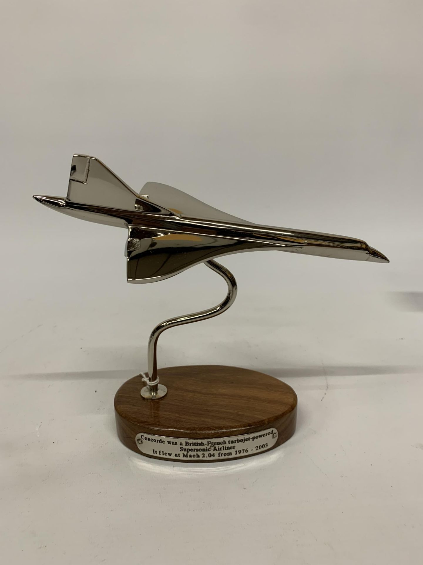 A CHROME MODEL OF CONCORDE ON A WOODEN BASE HEIGHT 19CM