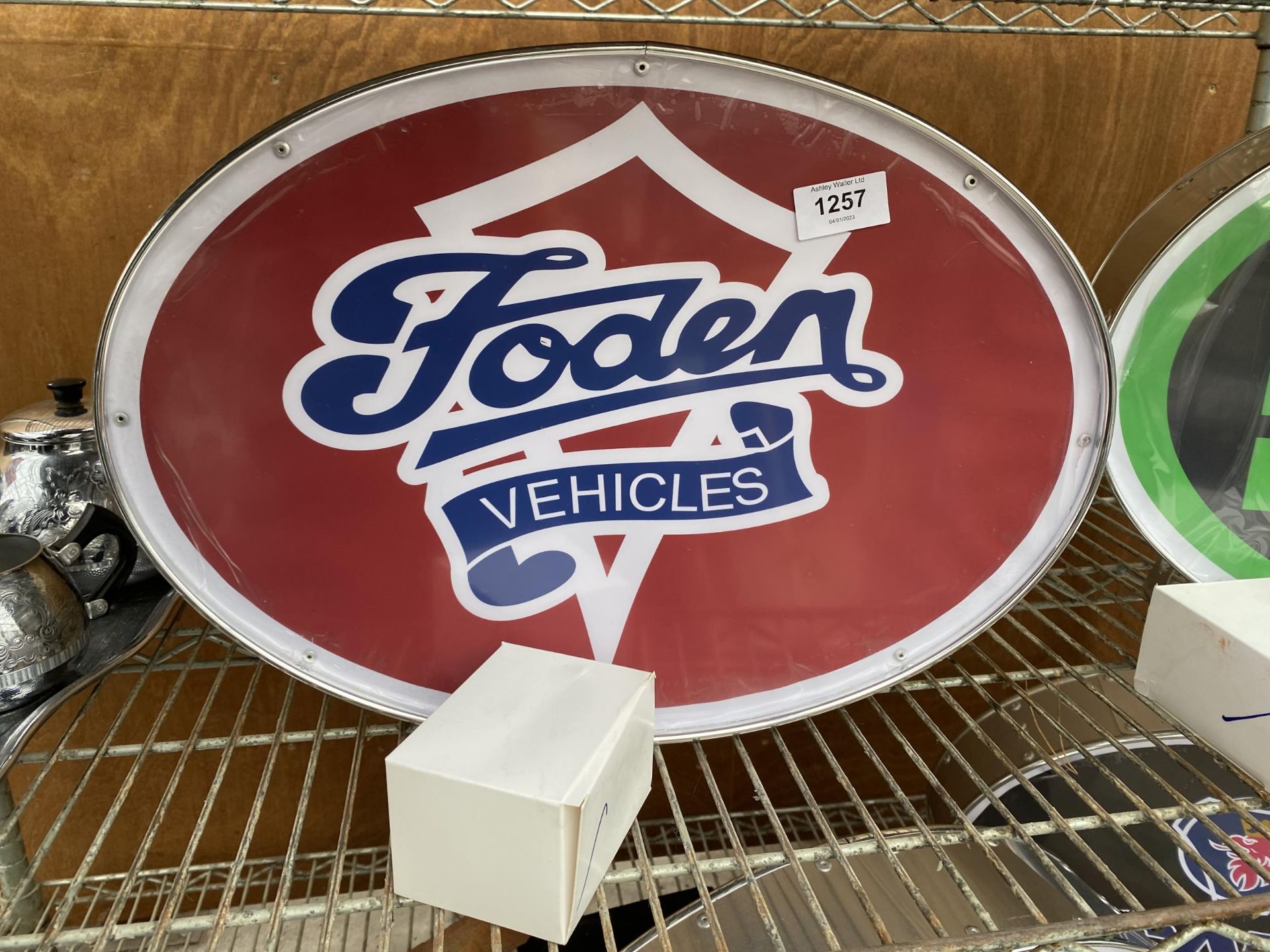 AN ILLUMINATED 'FODEN' SIGN WITH PLUG AND LEAD