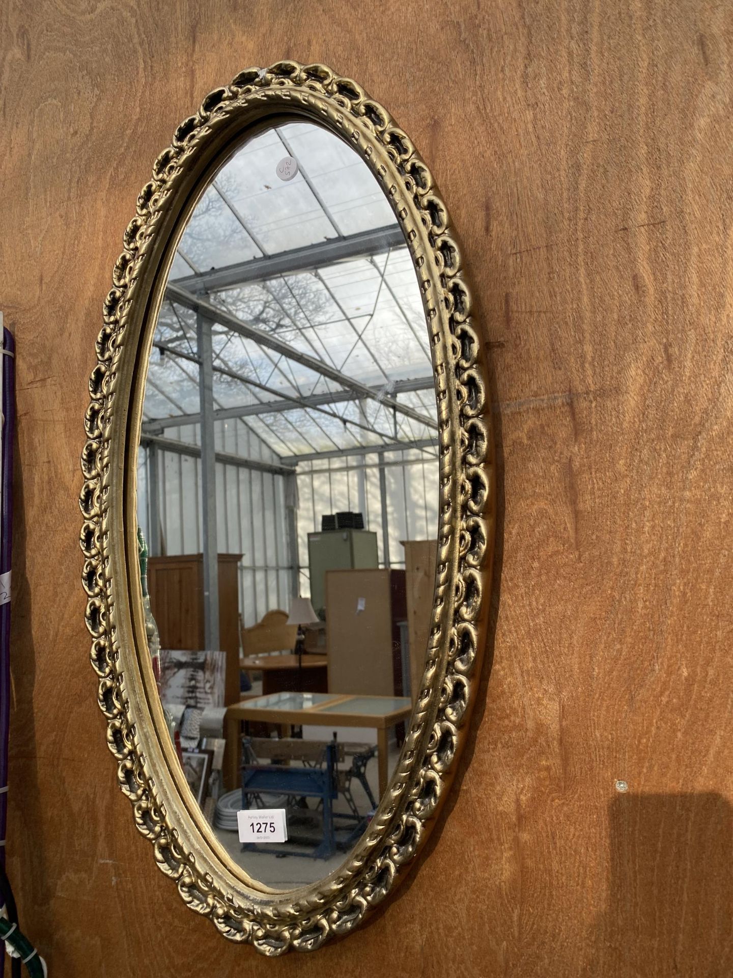 A DECORATIVE GILT FRAMED OVAL WALL MIRROR