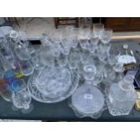A LARGE COLLECTION OF GLASS WARE TO INLCUDE DECANTERS, WINE GLASSES, BOWLS AND BRANDY GLASSES ETC