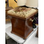 A MAHOGANY OTTOMAN ON BUN FEET WITH BRASS HANDLES AND FLORAL EMBROIDERED SEAT