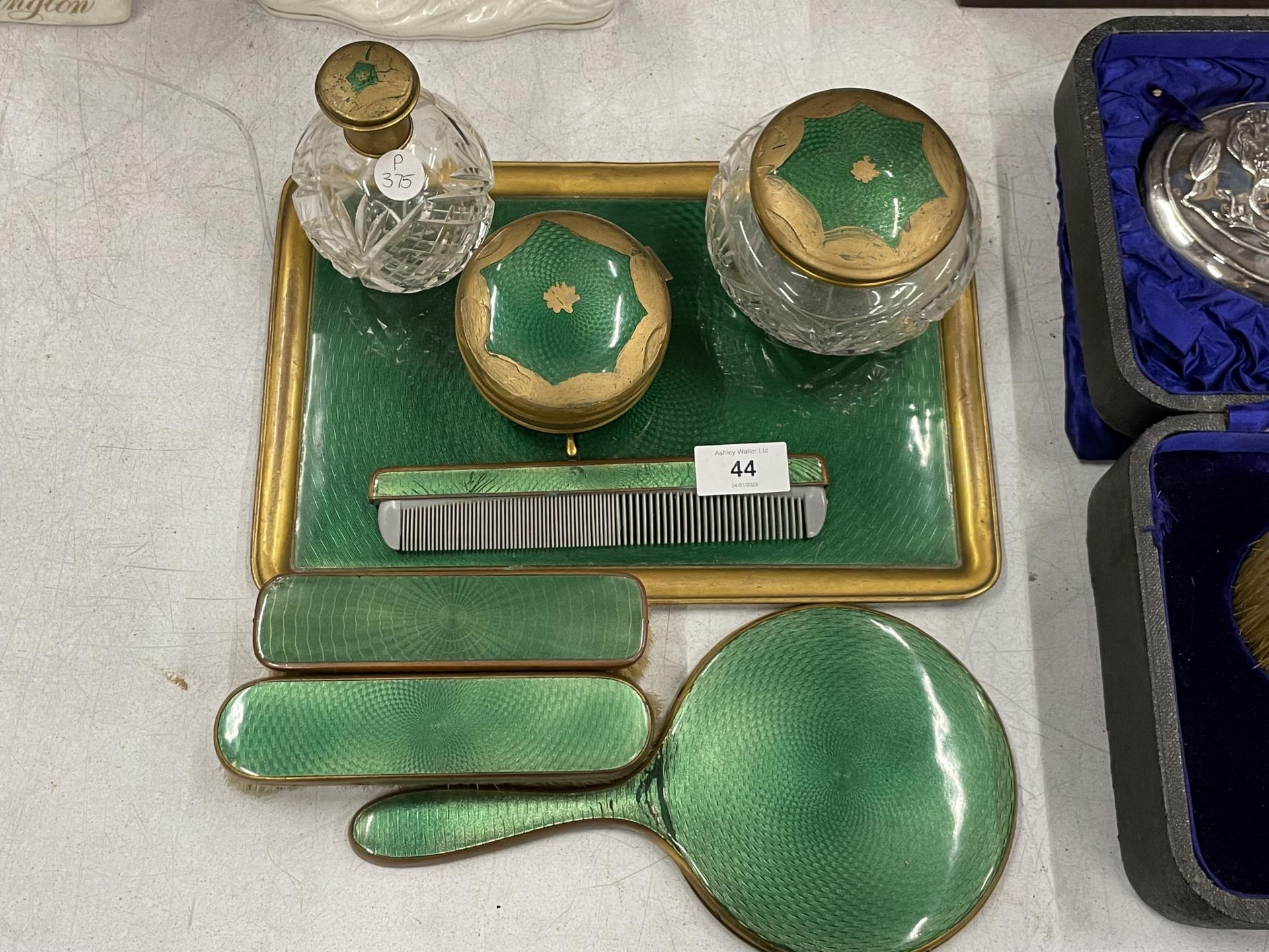 A VINTAGE GREEN ENAMEL BACKED DRESSING TABLE SET COMPRISING TRAY, BRUSHES, MIRROR AND POTS