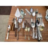 AN ASSORTMENT OF FLAT WARE TO INCLUDE CAKE SLICES, TOASTING FORKS AND SPOONS ETC