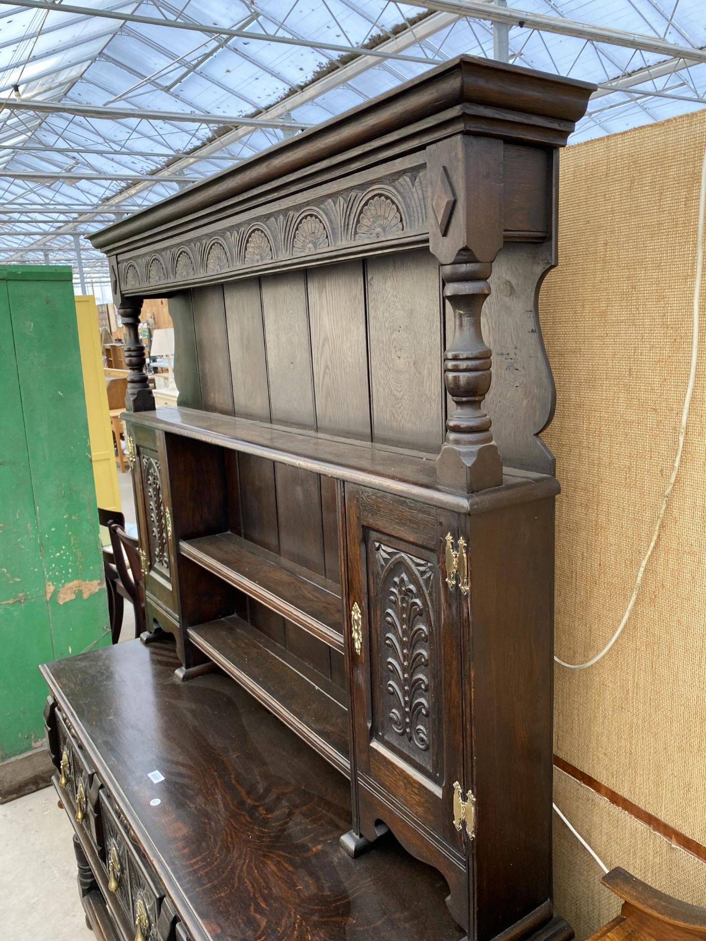 AN OAK JACOBEAN STYLE DRESSER WITH PLATE RACK ENCLOSING CUPBOARDS, THREE CARVED DRAWERS TO BASE ON - Image 2 of 6