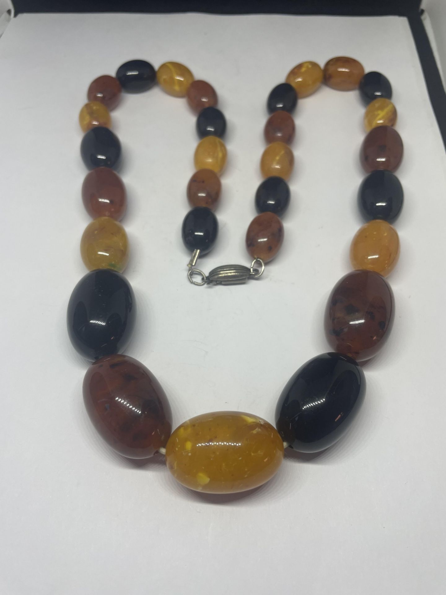 A LARGE MULTI COLOURED GRADUATED AMBER NECKLACE LENGTH 70CM