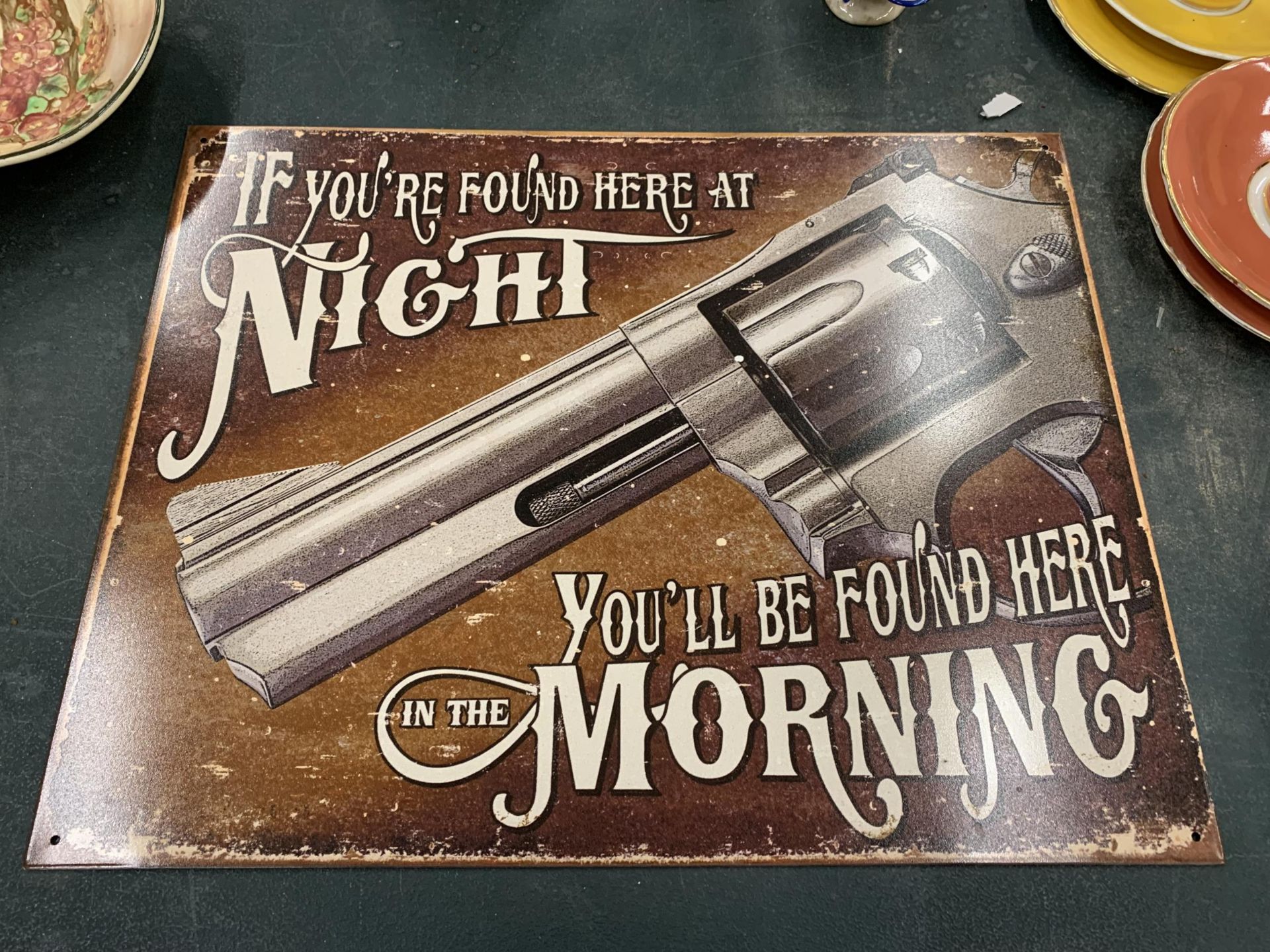 A TIN PLATE SIGN 'IF YOU'RE FOUND HERE AT NIGHT, YOU'LL BE FOUND HERE IN THE MORNING' 40.5CM X 31.