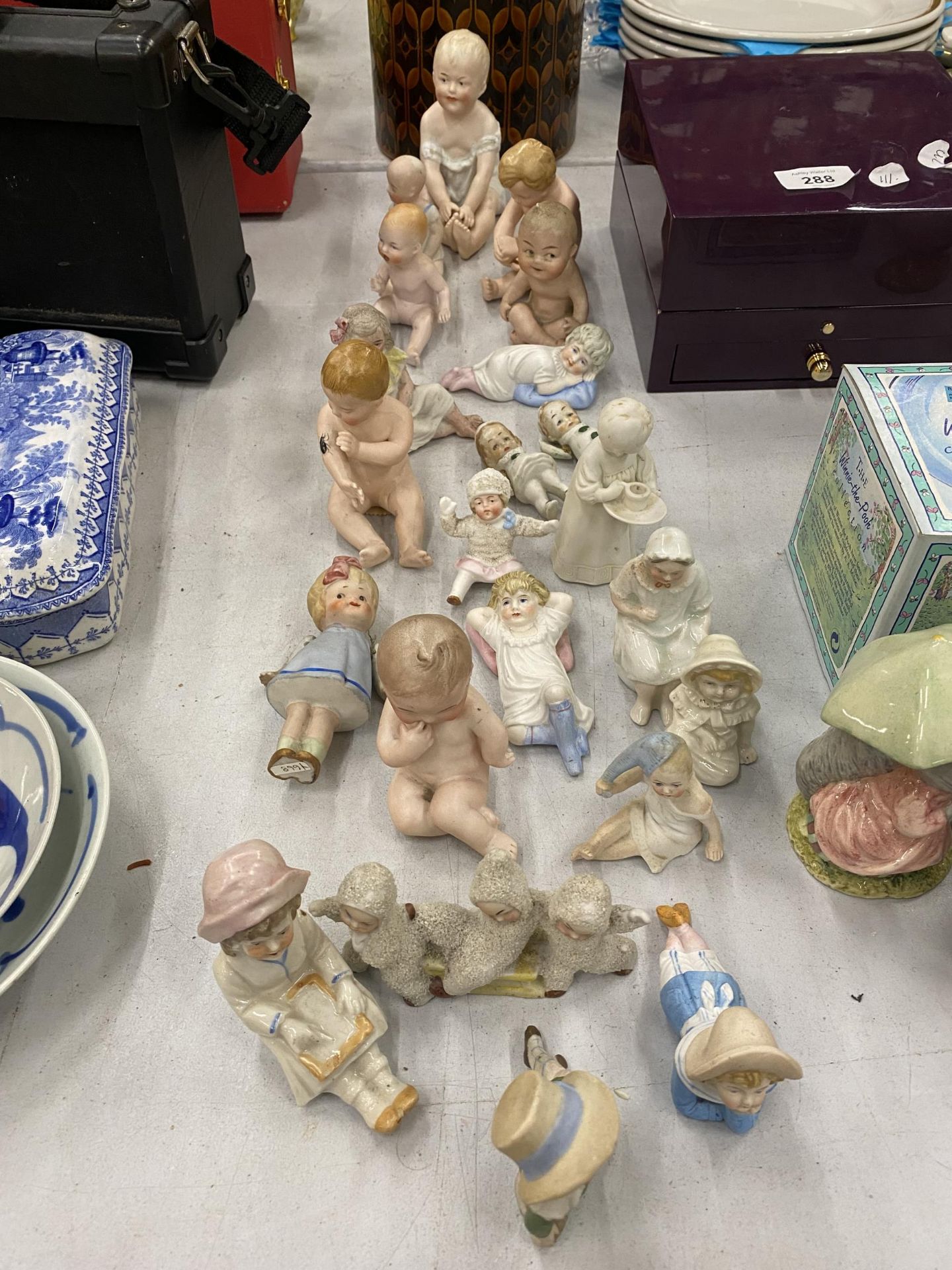 A COLLECTION OF CHILD THEMED CERAMICS TO INCLUDE A GEBRUDER-HEUBACH CIRCA 1910 'PIANO BABY'