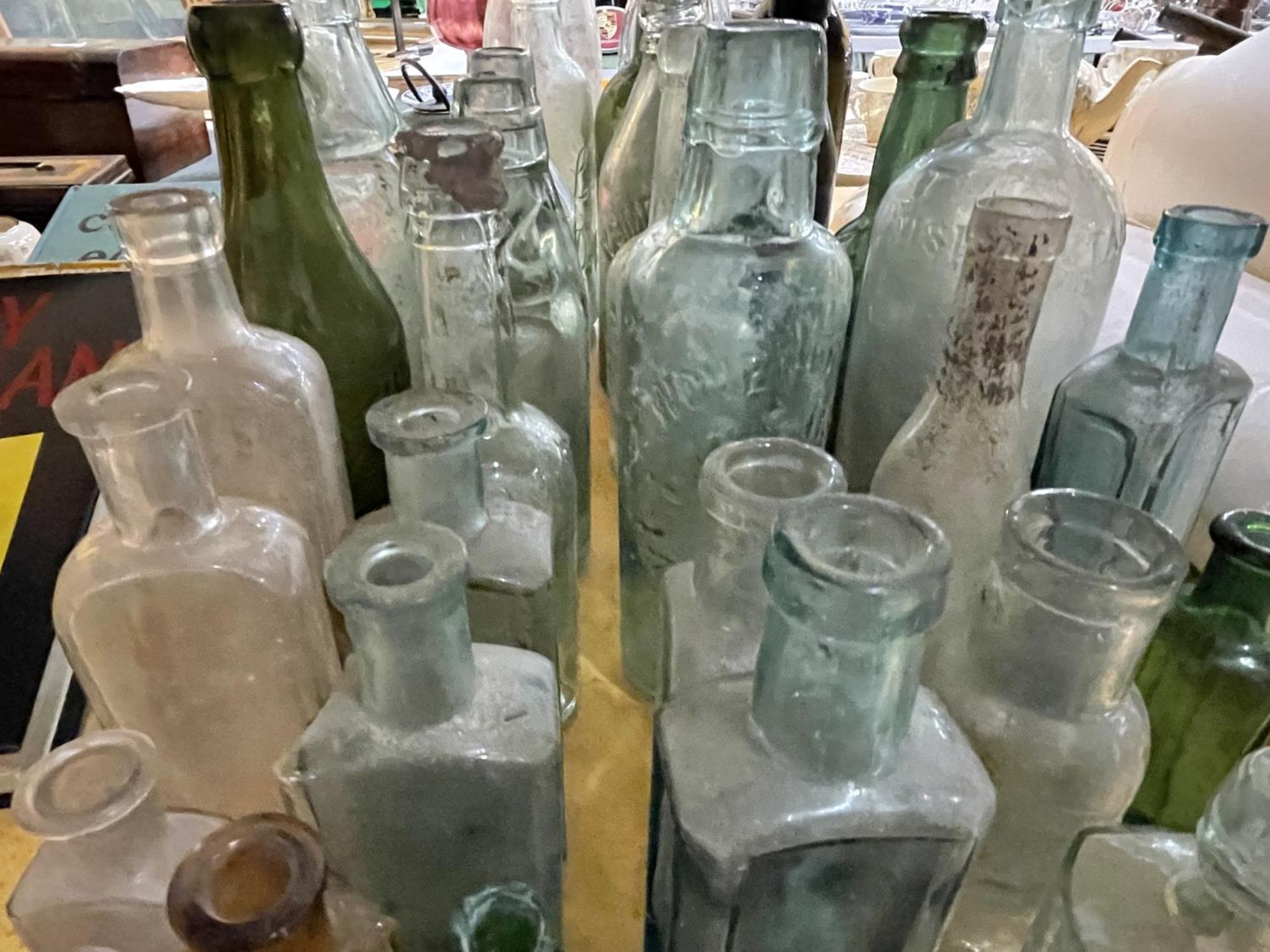 A LARGE QUANTITY OF VINTAGE GLASS BOTTLES TO INCLUDE SOME WITH GLASS MARBLES - Image 3 of 4