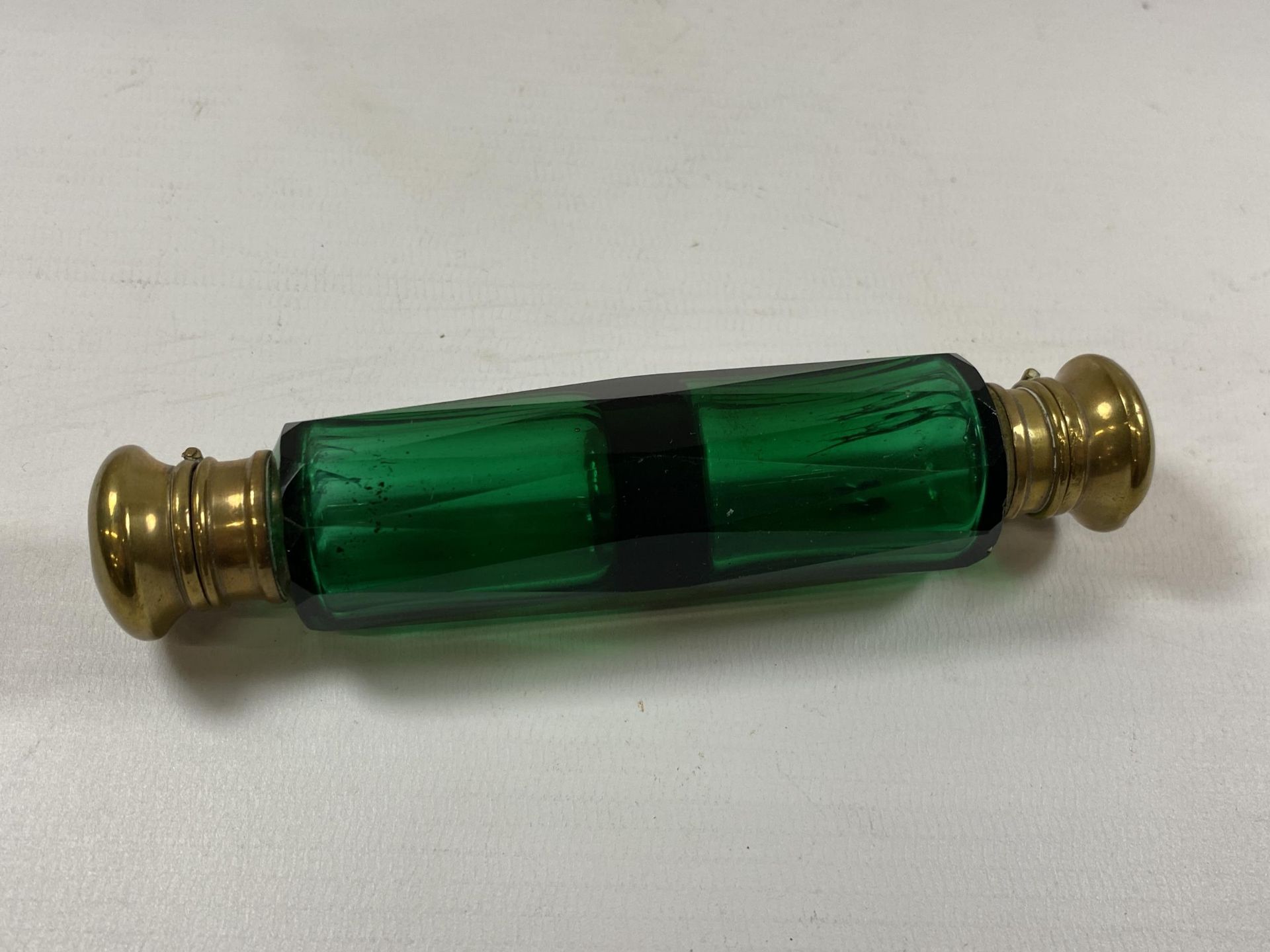 A VINTAGE GREEN GLASS AND BRASS TOPPED DOUBLE SIDED PERFUME BOTTLE