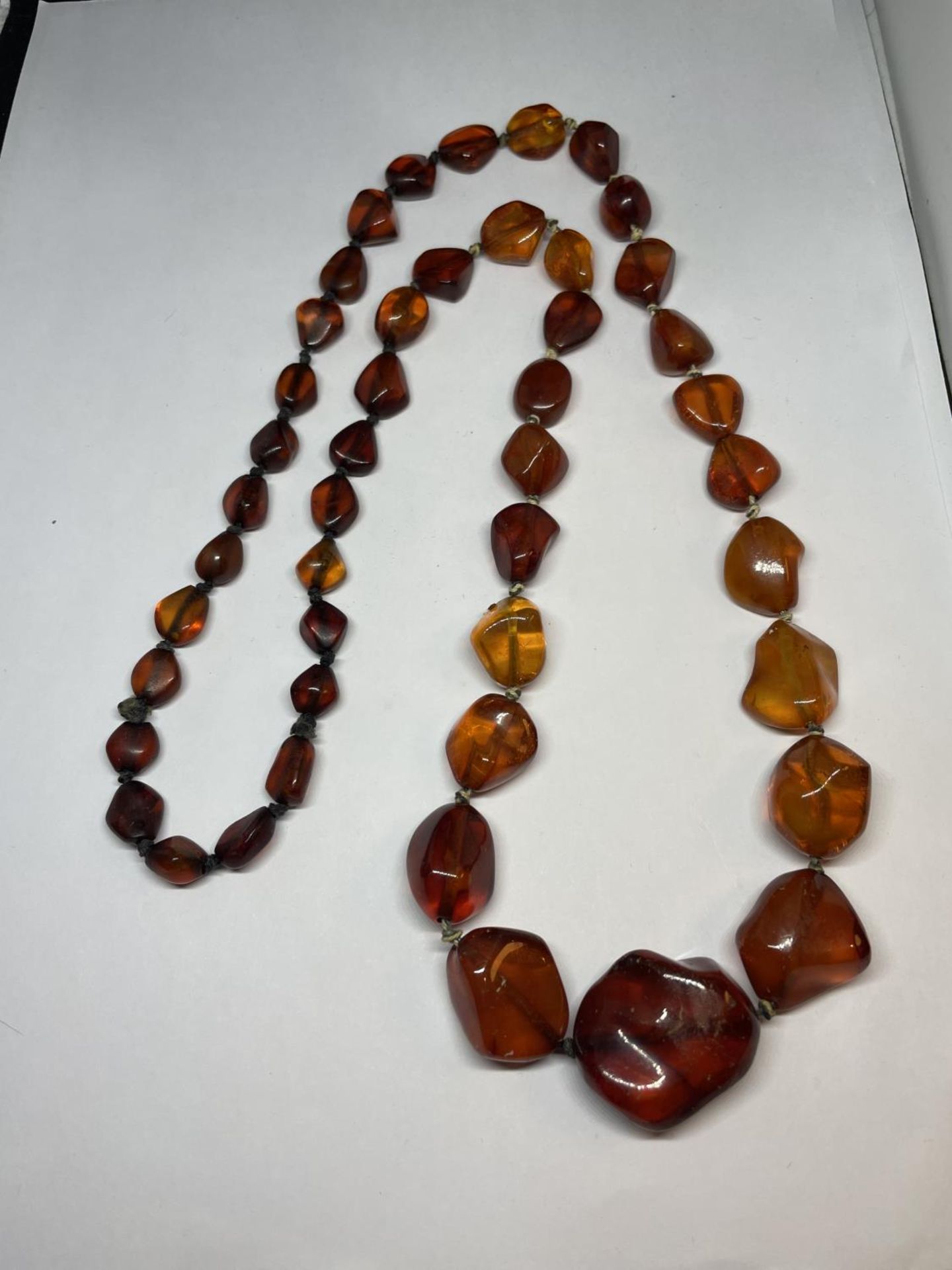 A GRADUATED AMBER EFFECT NECKLACE APRROXIMATELY 44CM LONG