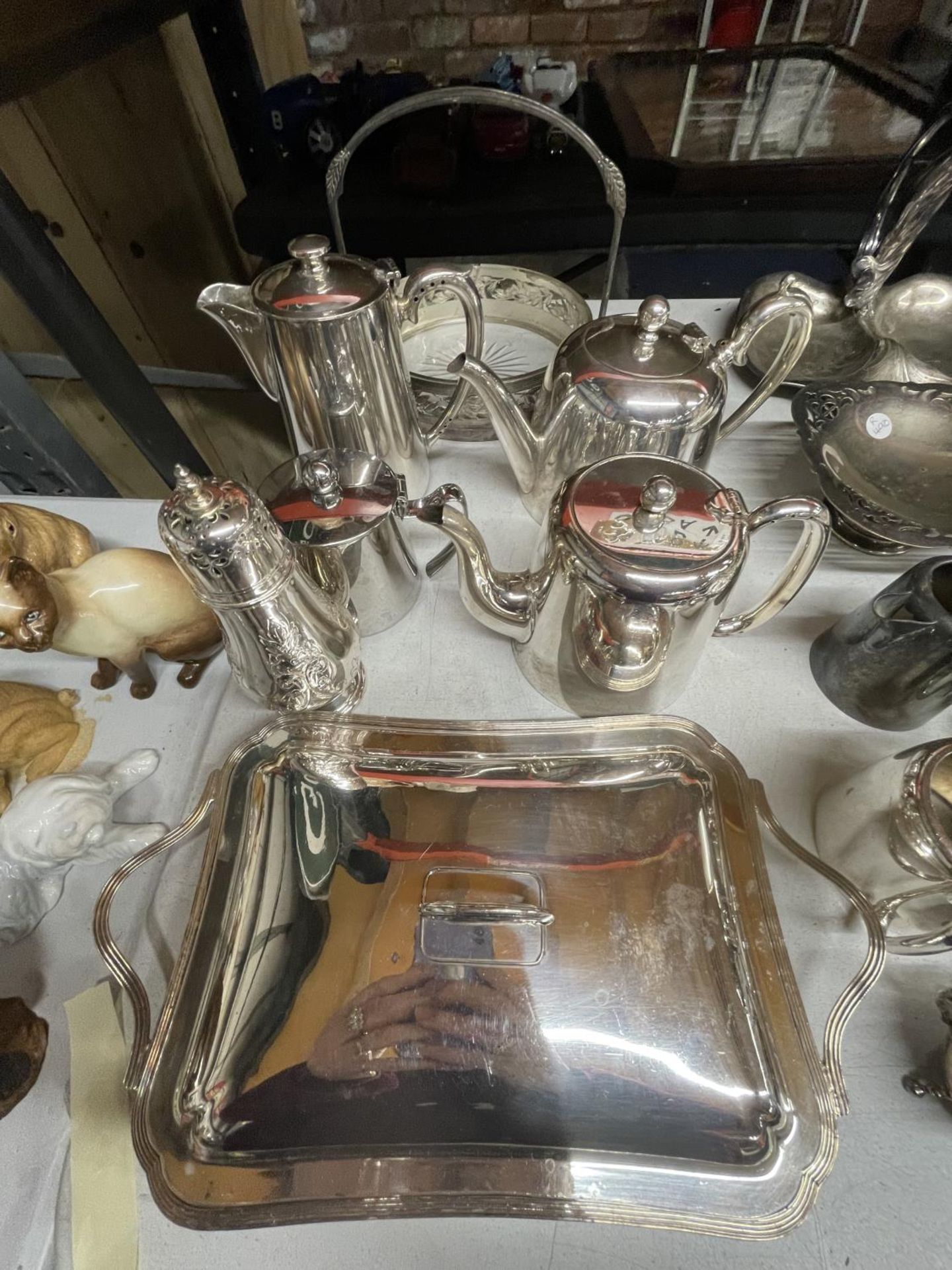 A QUANTITY OF SILVER PLATED ITEMS TO INCLUDE COFFEE AND TEAPOTS, A SUGAR SHAKER, A HANDLED BOWL,