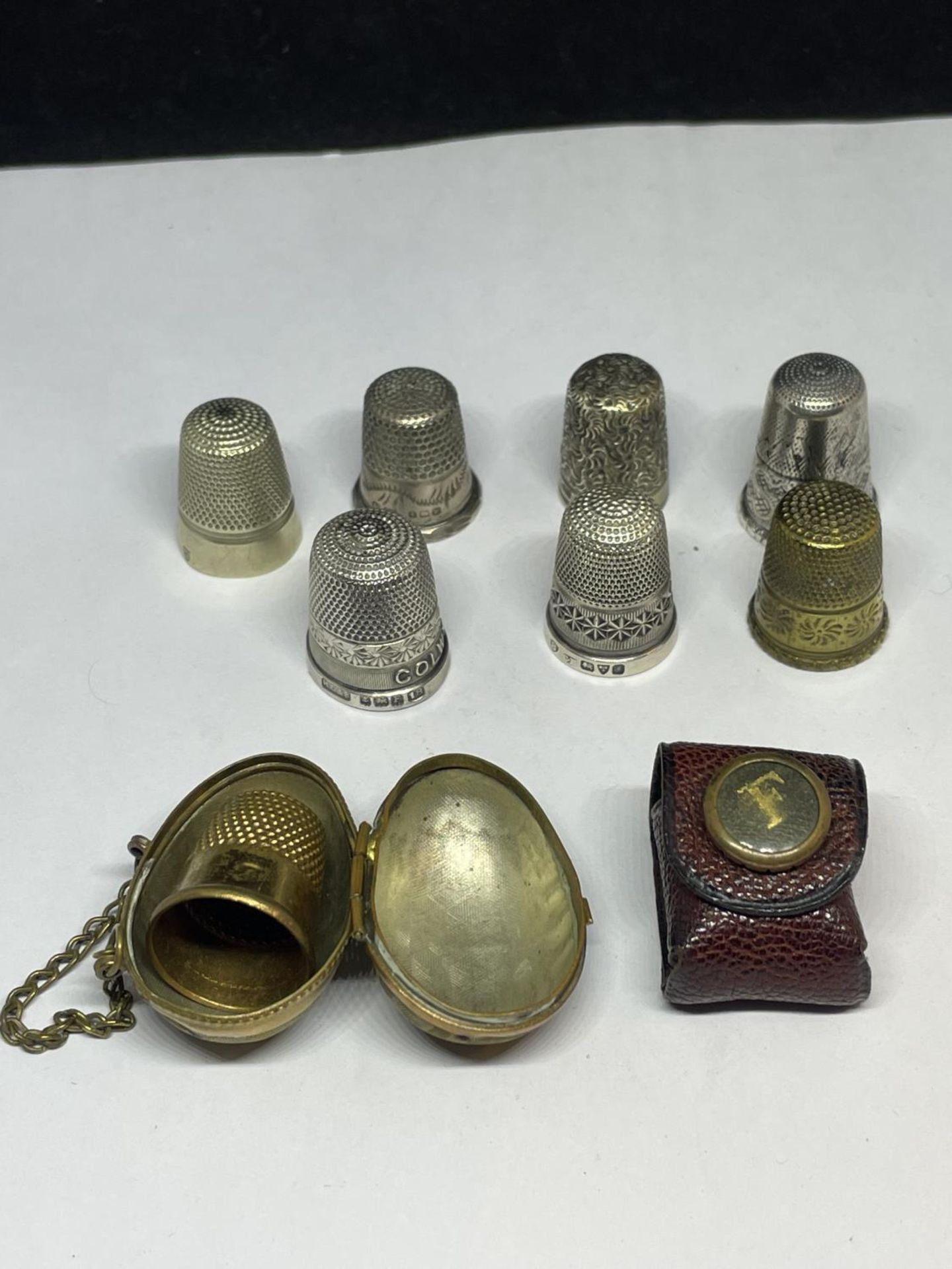 EIGHT VARIOUS THIMBLES TO INCLUDE TWO CHESTER AND TWO BIRMINGHAM HALLMARKED, A LEATHER CASE AND A