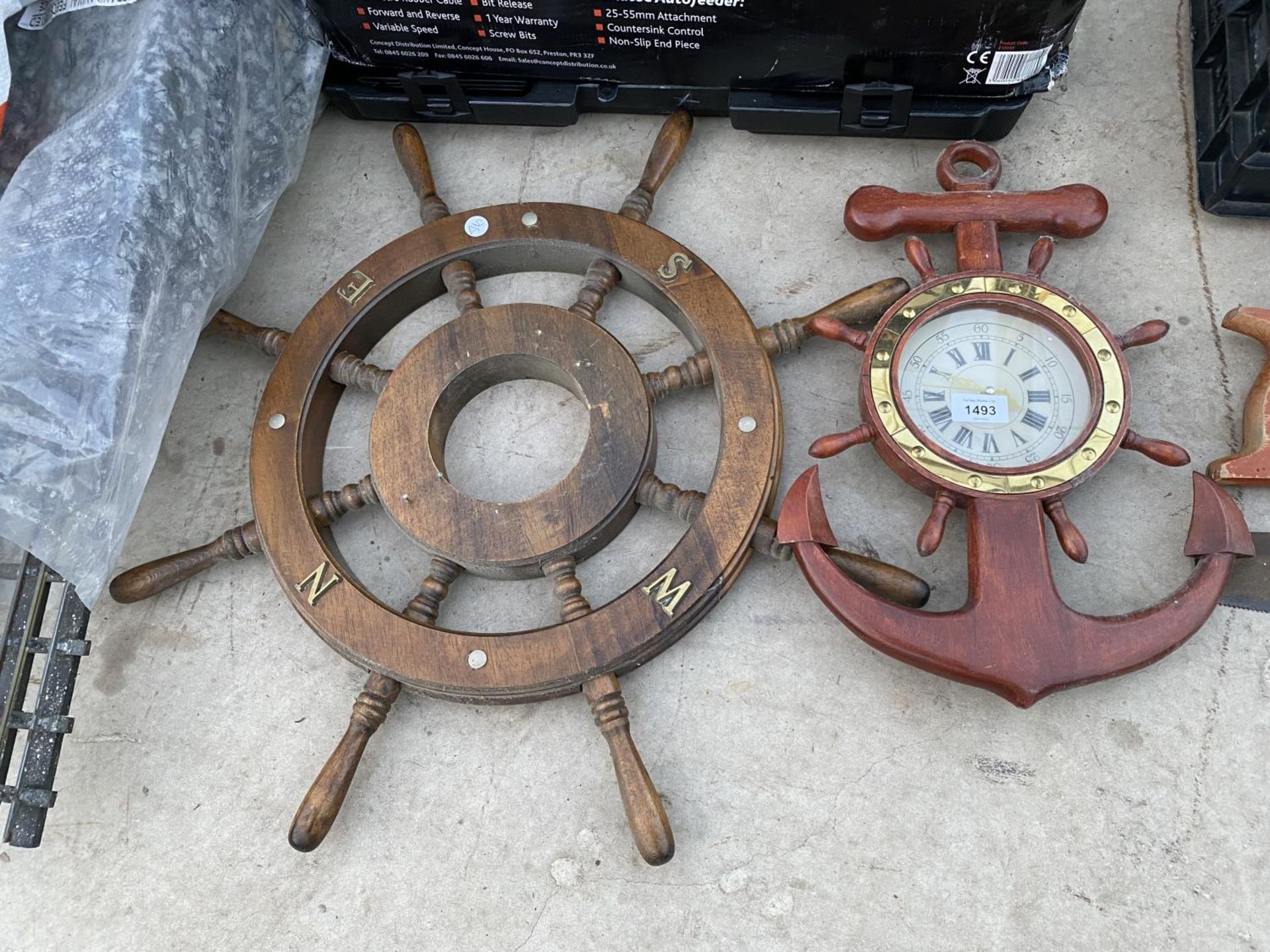 A WOODEN SHIPS WHEEL AND A NAUTICAL CLOCK