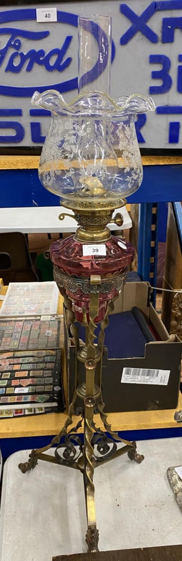 A LARGE VICTORIAN OIL LAMP WITH CRANBERRY RESEVOIR AND ETCHED GLASS SHADE ON TWISTED EFFECT BRASS