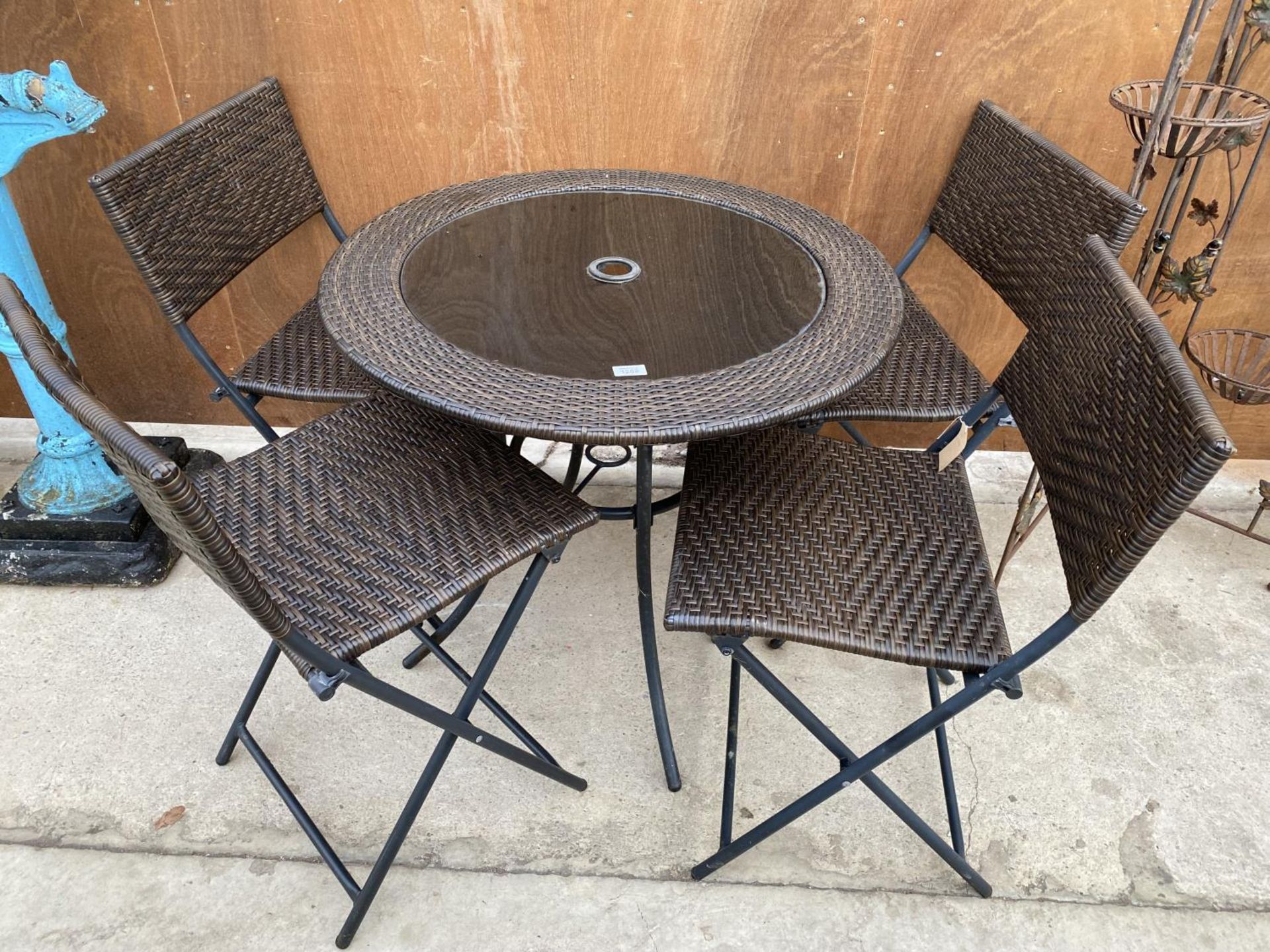 A RATTAN FIVE PIECE BISTRO SET TO INCLUDE ROUND TABLE AND FOUR CHAIRS