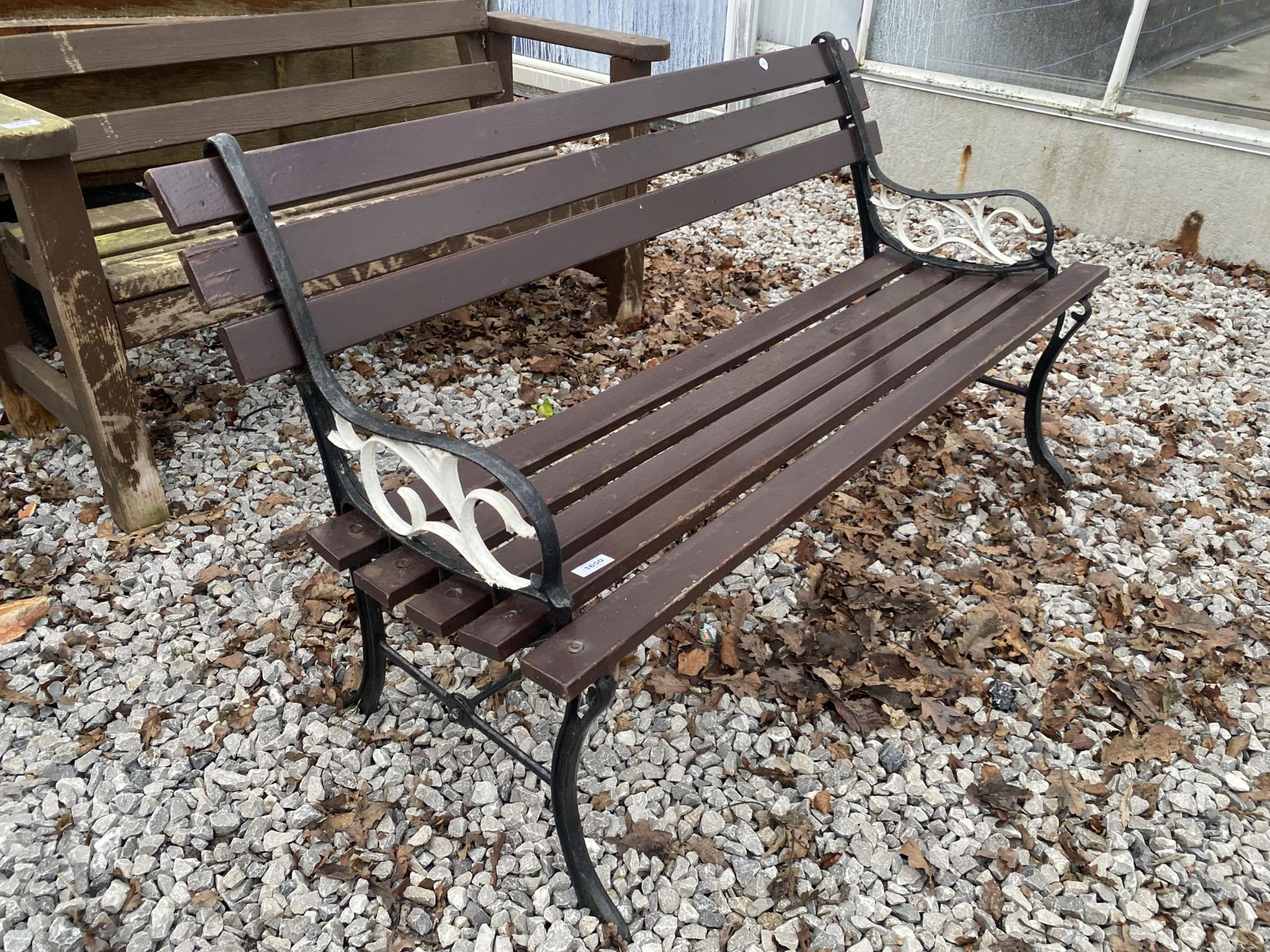 A SLATTED GARDEN BENCH WITH CAST BENCH ENDS