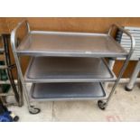 A STAINLESS STEEL FOUR WHEELED THREE TIER TROLLEY
